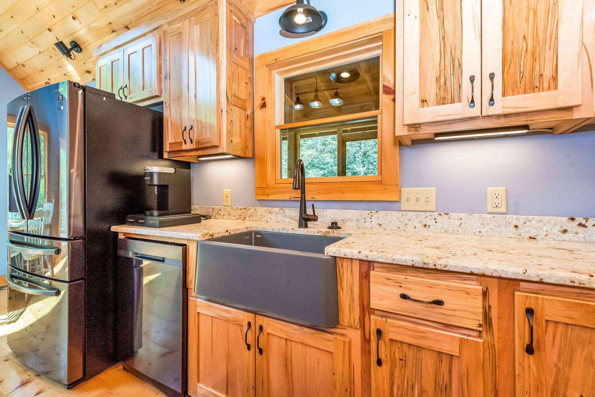 The inclusion of a farm sink and blue stainless appliances adds a unique touch to the kitchen, showcasing the well-thought-out design and attention to detail present throughout the cabin.