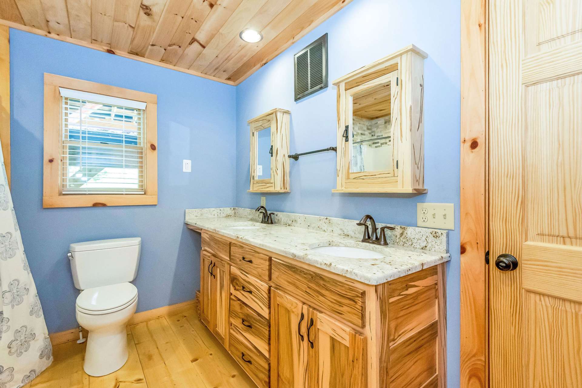 The main level bath vanity features granite countertops with double sinks.