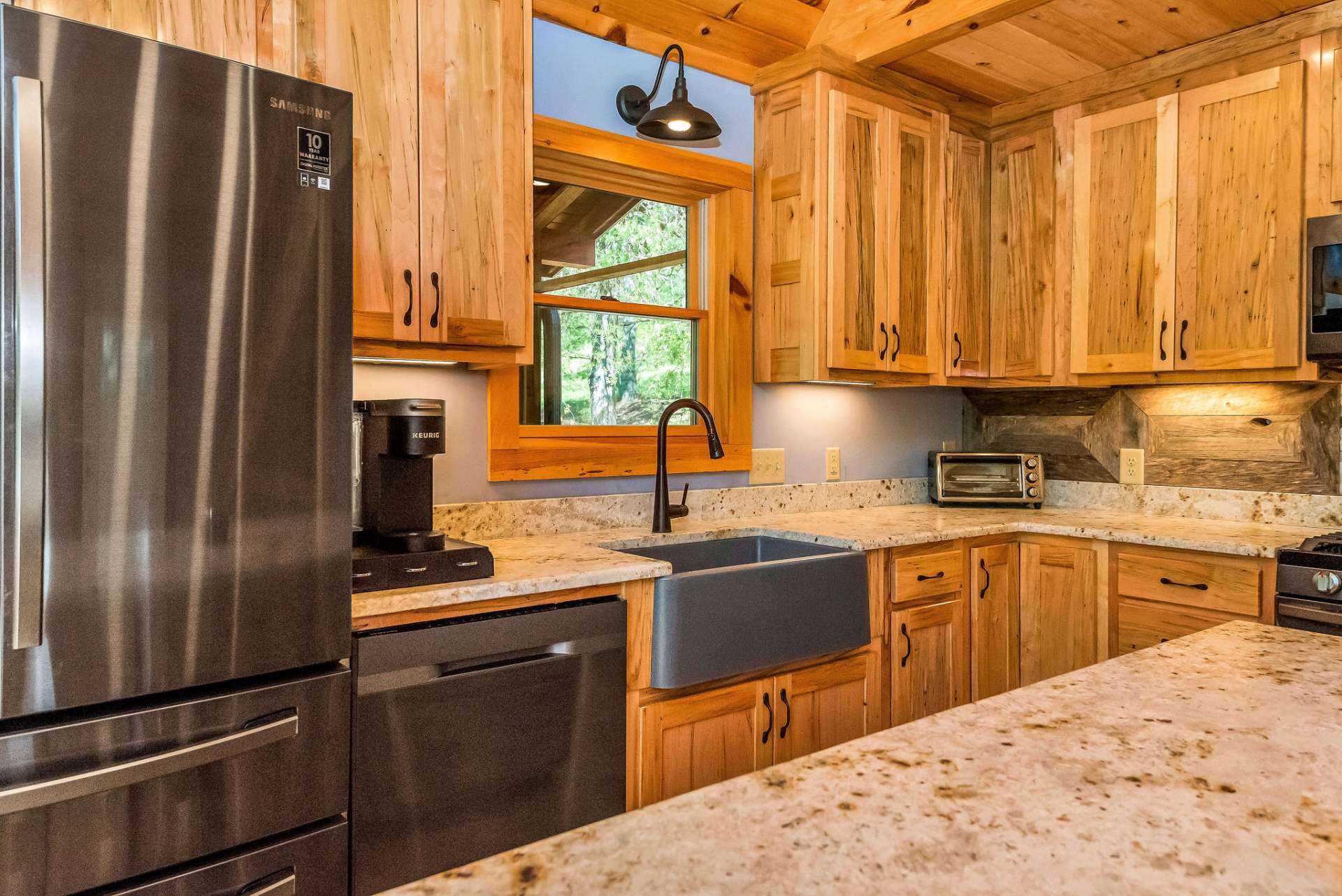 The granite countertops with warm tones speckled throughout complement the wormy maple cabinets giving a harmonious blend of natural elements.