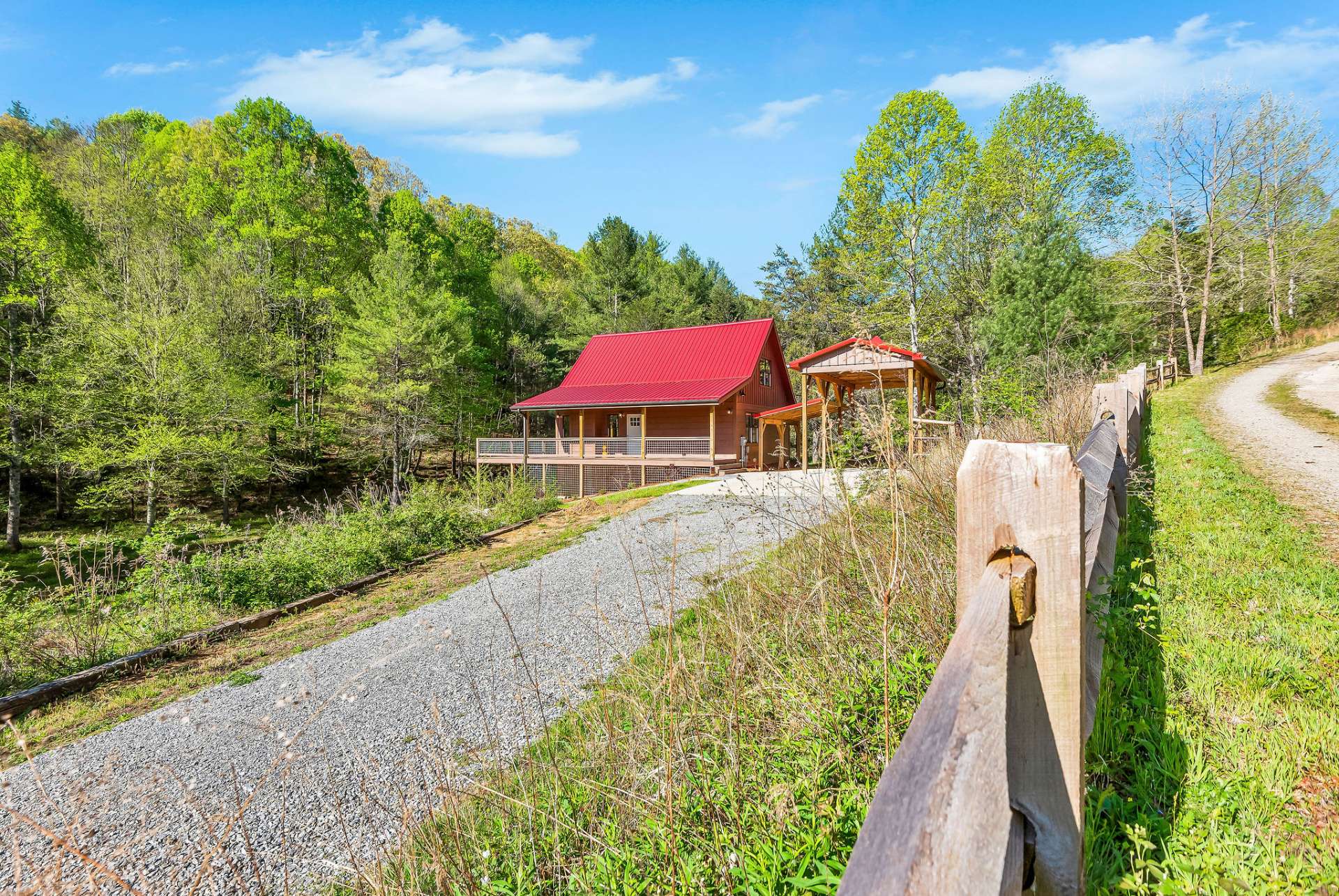 A private driveway leads down to the cabin set against a backdrop of mountain foilage.