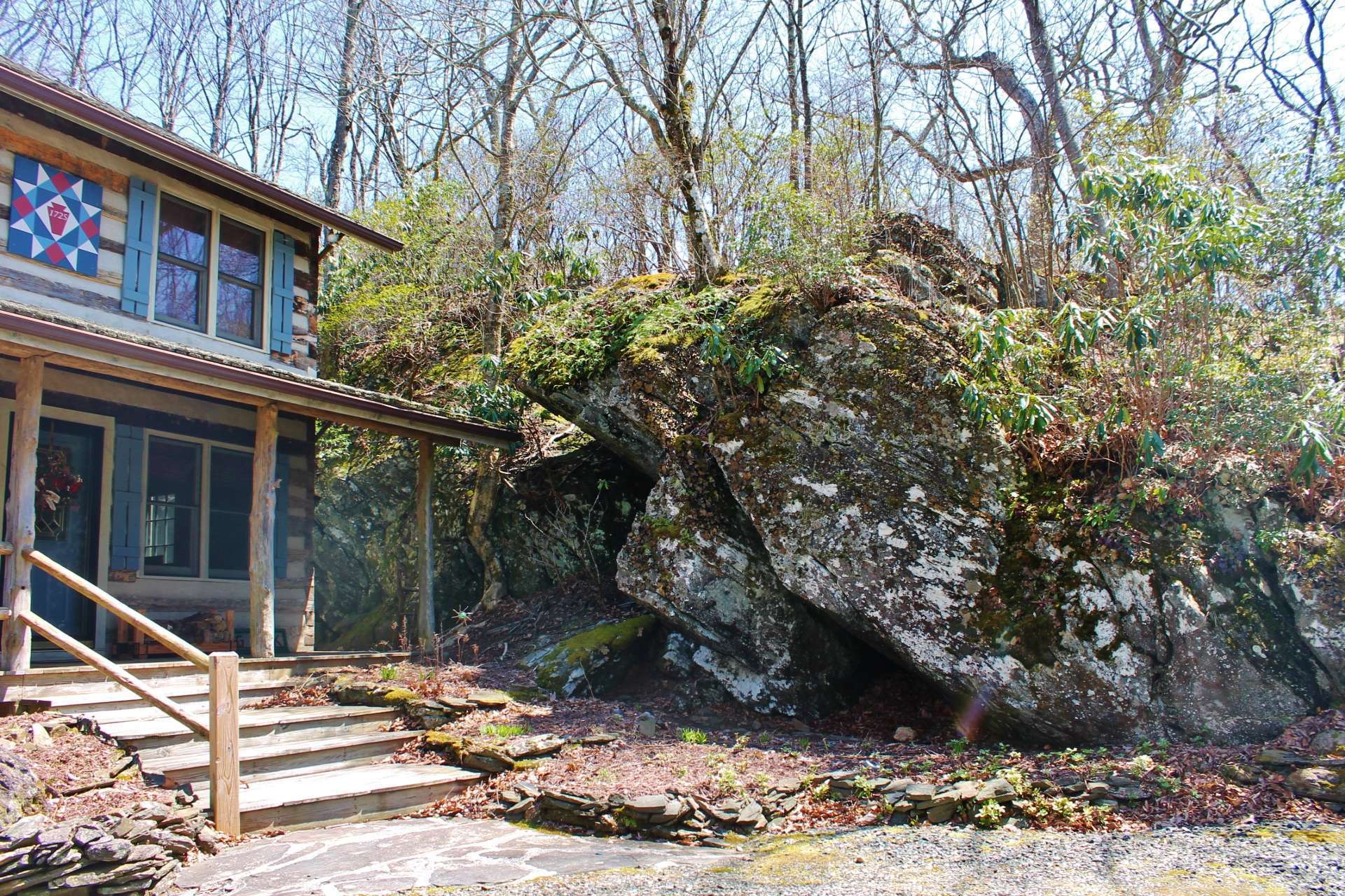 This classic Stonebridge cabin is well known to neighbors in this friendly log cabin community  as  "BIG ROCK".  A massive boulder and  rock formation runs the entire side of the cabin.
