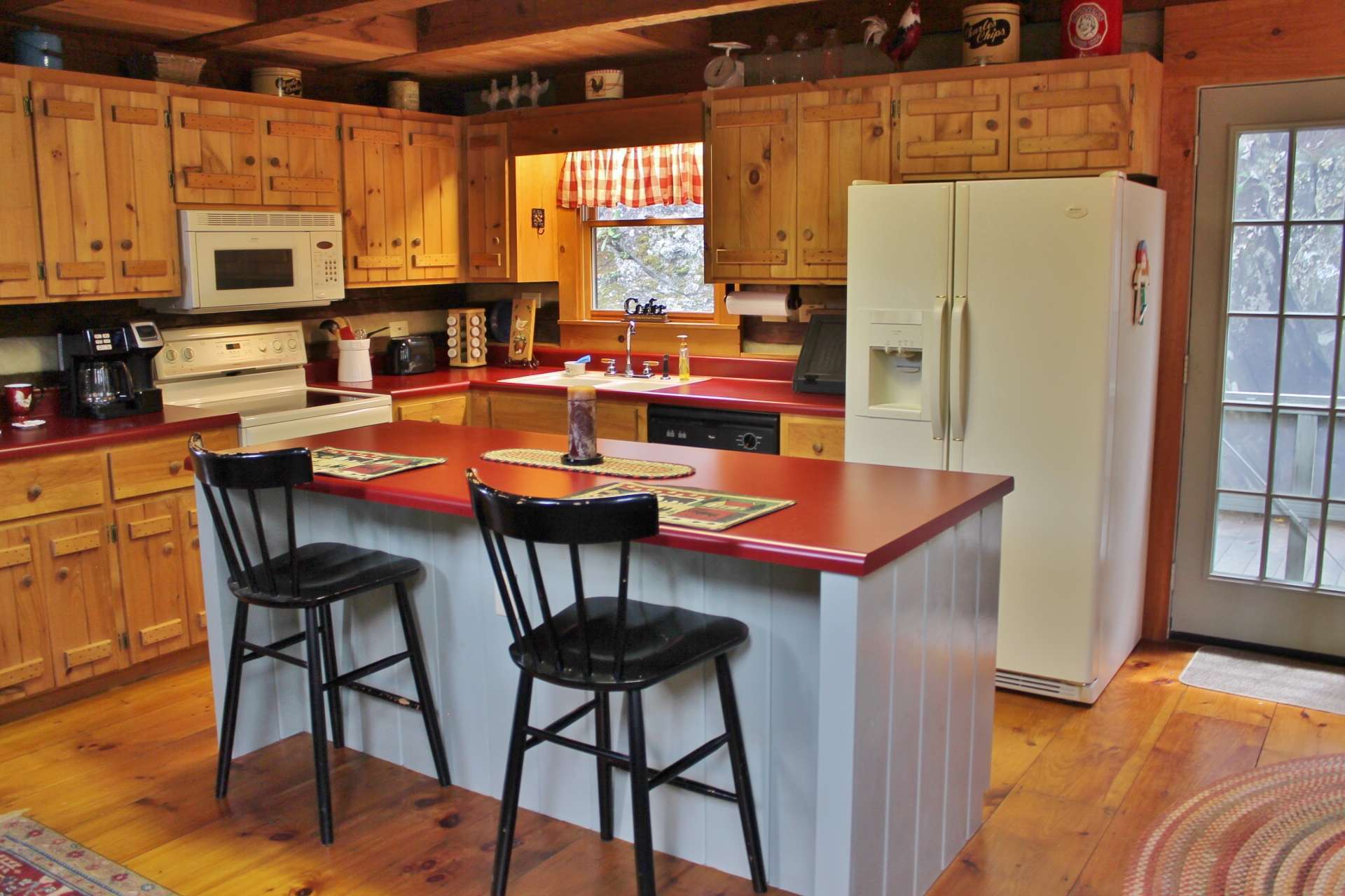 This bright open kitchen offers ample work and storage space and center island to allow for quick meals or sharing a family recipe. The dining area is strategically placed to enjoy the outdoor scenery while dining indoors.