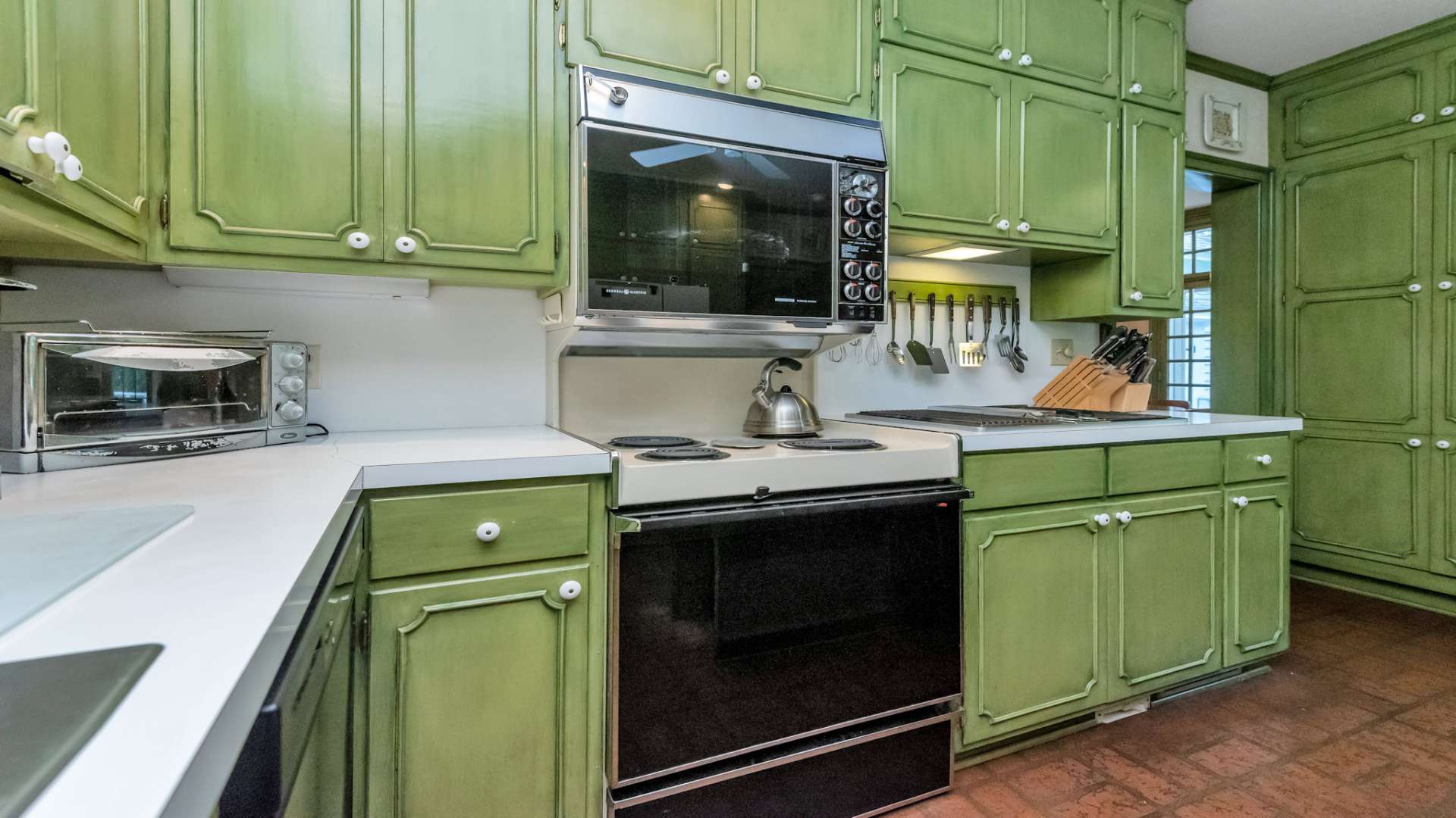 Appliances include a refrigerator, an electric range with double ovens, a downdraft cooktop, and dishwasher.