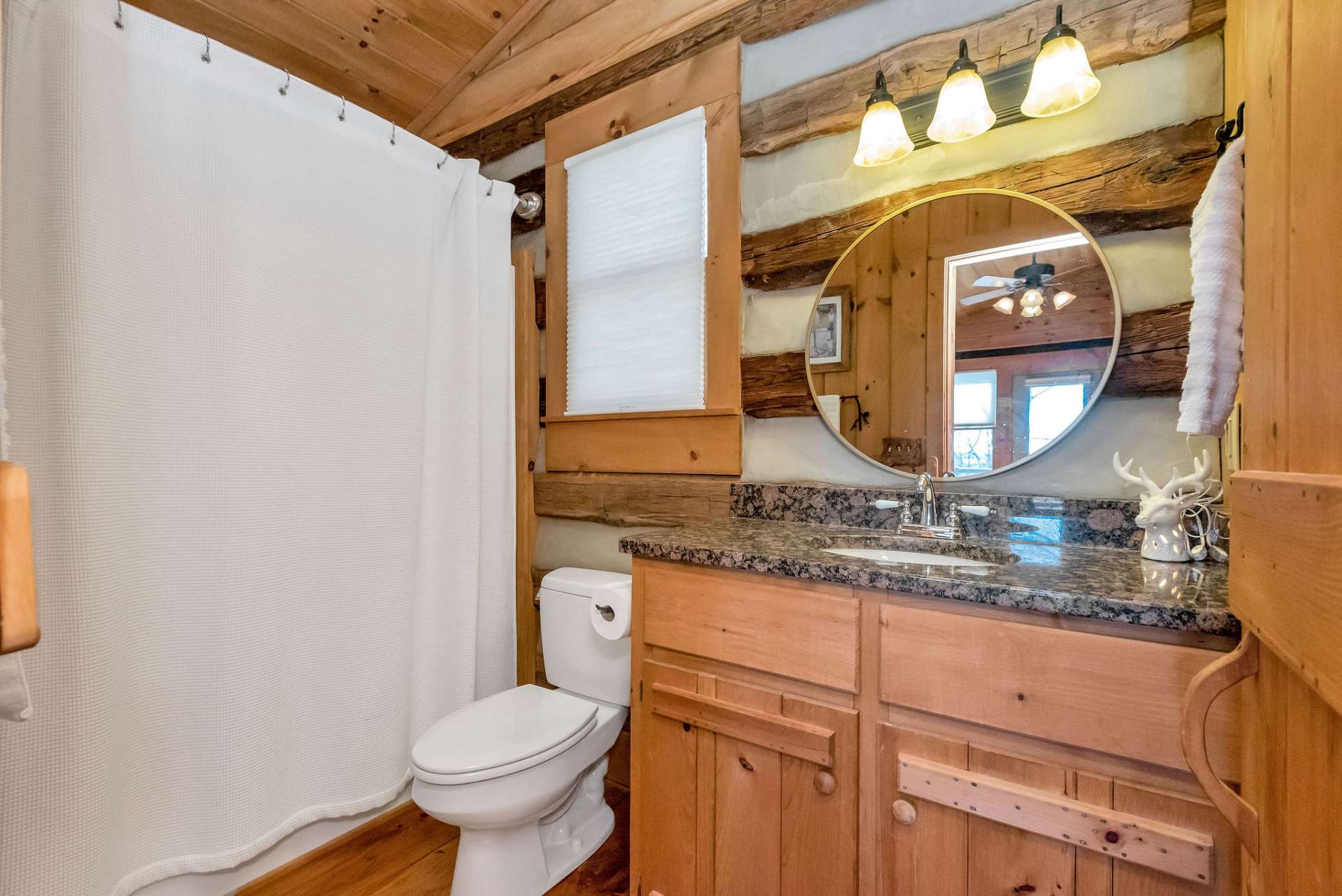 Main level full bath is located in the primary bedroom with granite countertops and shower/tub combo.