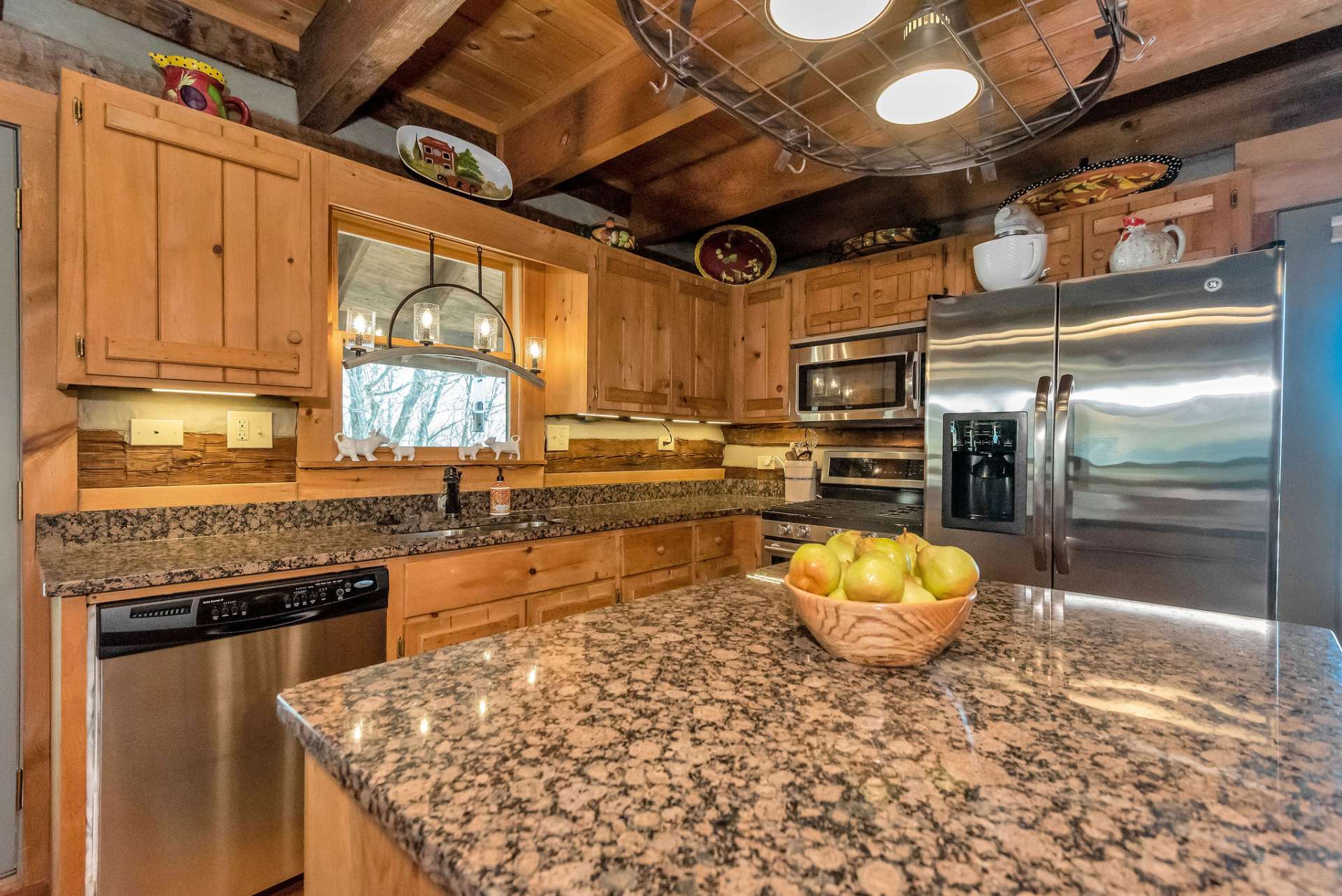 The gas range and stainless appliances give this kitchen a desired modern rustic motif.