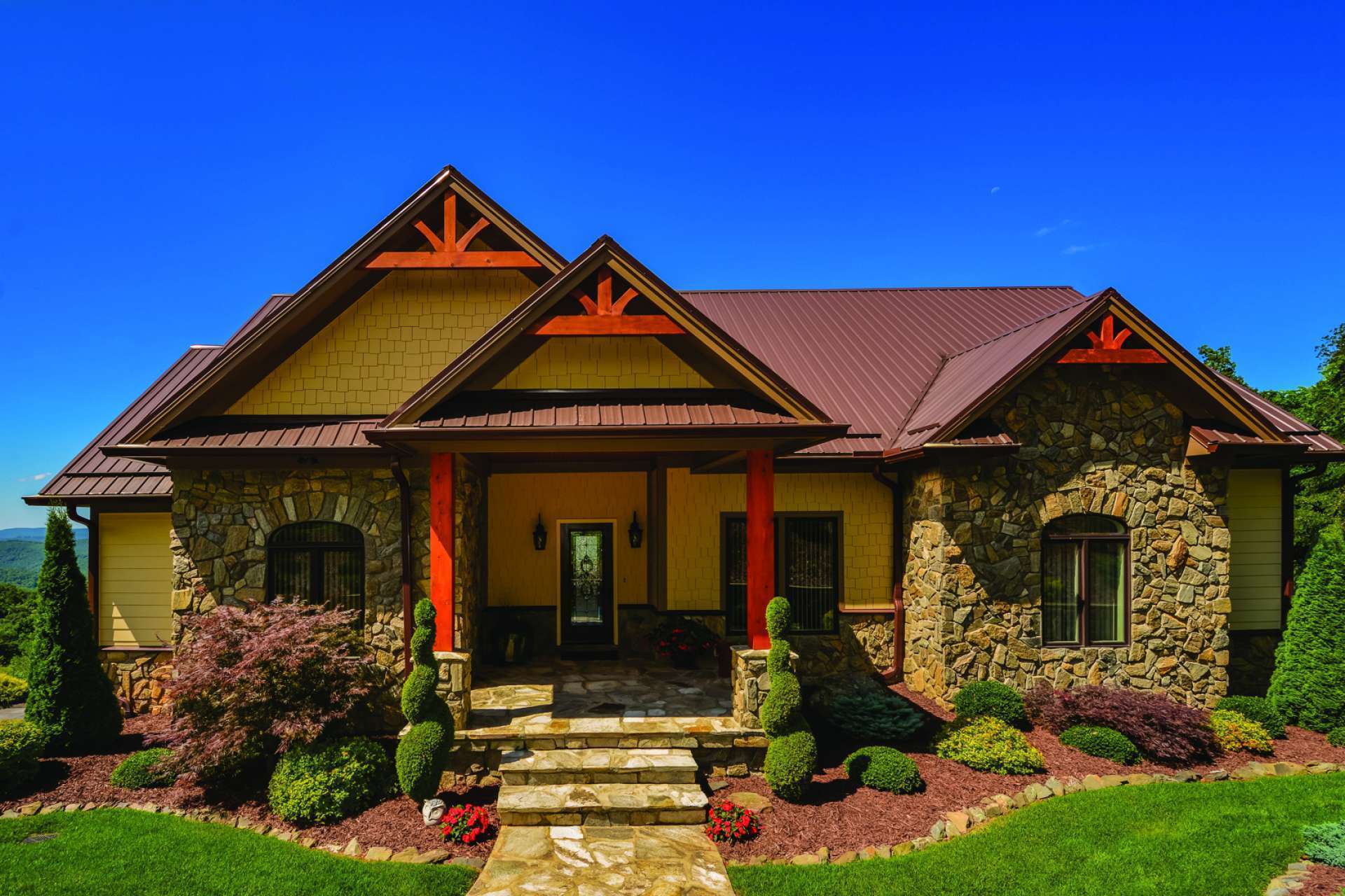 As you approach the home, the stone exterior and professionally landscaped yard with mature plants and trees convey an undeniable message of quality. *Notice the attention to detail in the wooden gable décor along the roofline and the arched window casings, as well as the stone front steps, porch and walkway.