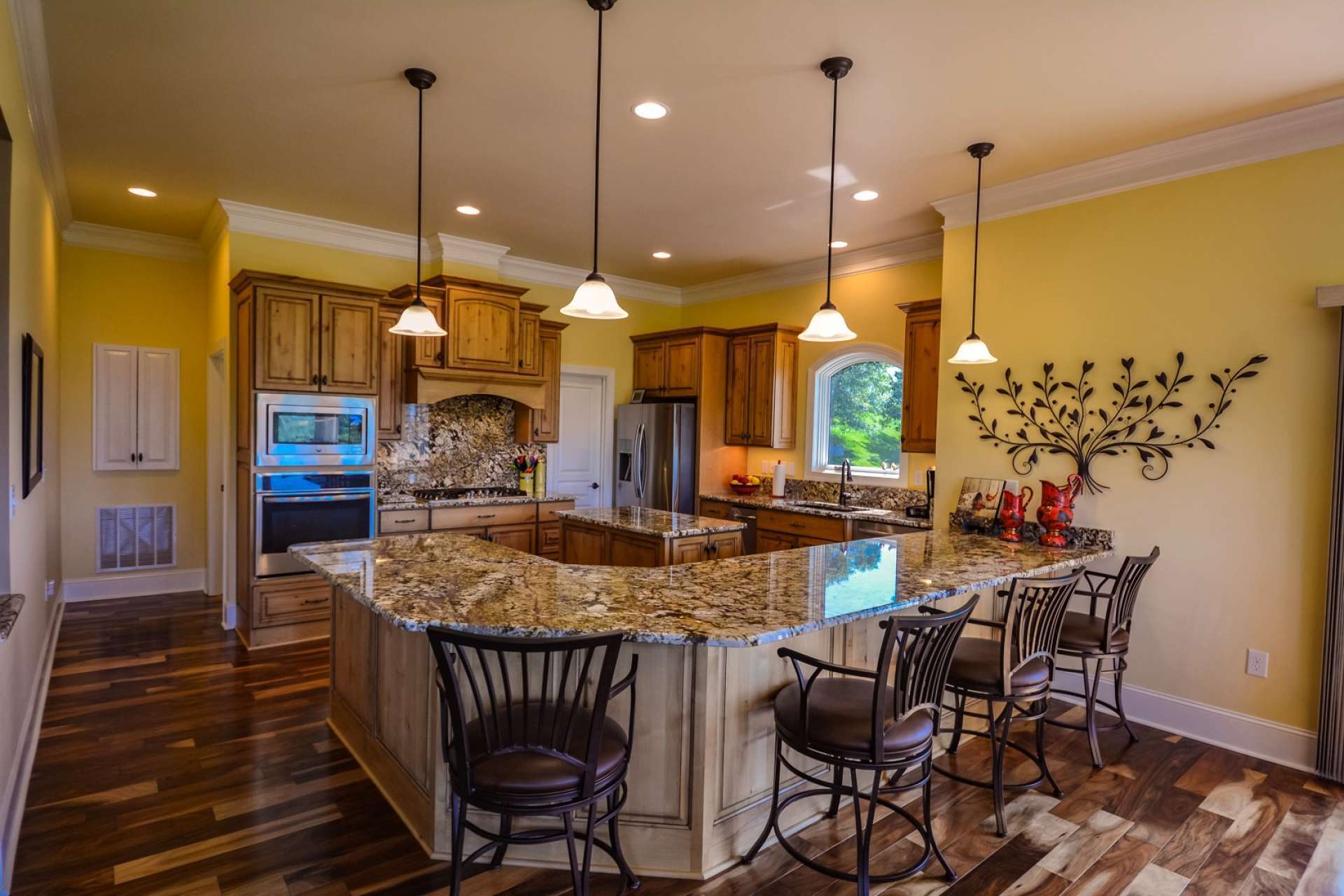 The kitchen is simple stunning, and loaded with special features such as custom made knotty alder cabinetry with full extension, soft close drawers and door, rich granite countertops and backsplash, 5-burner gas cooktop and built-in under counter ice maker, trash compactor and garbage disposal. The cabinets are designed and fabricated by Carolina Heritage Cabinetry.