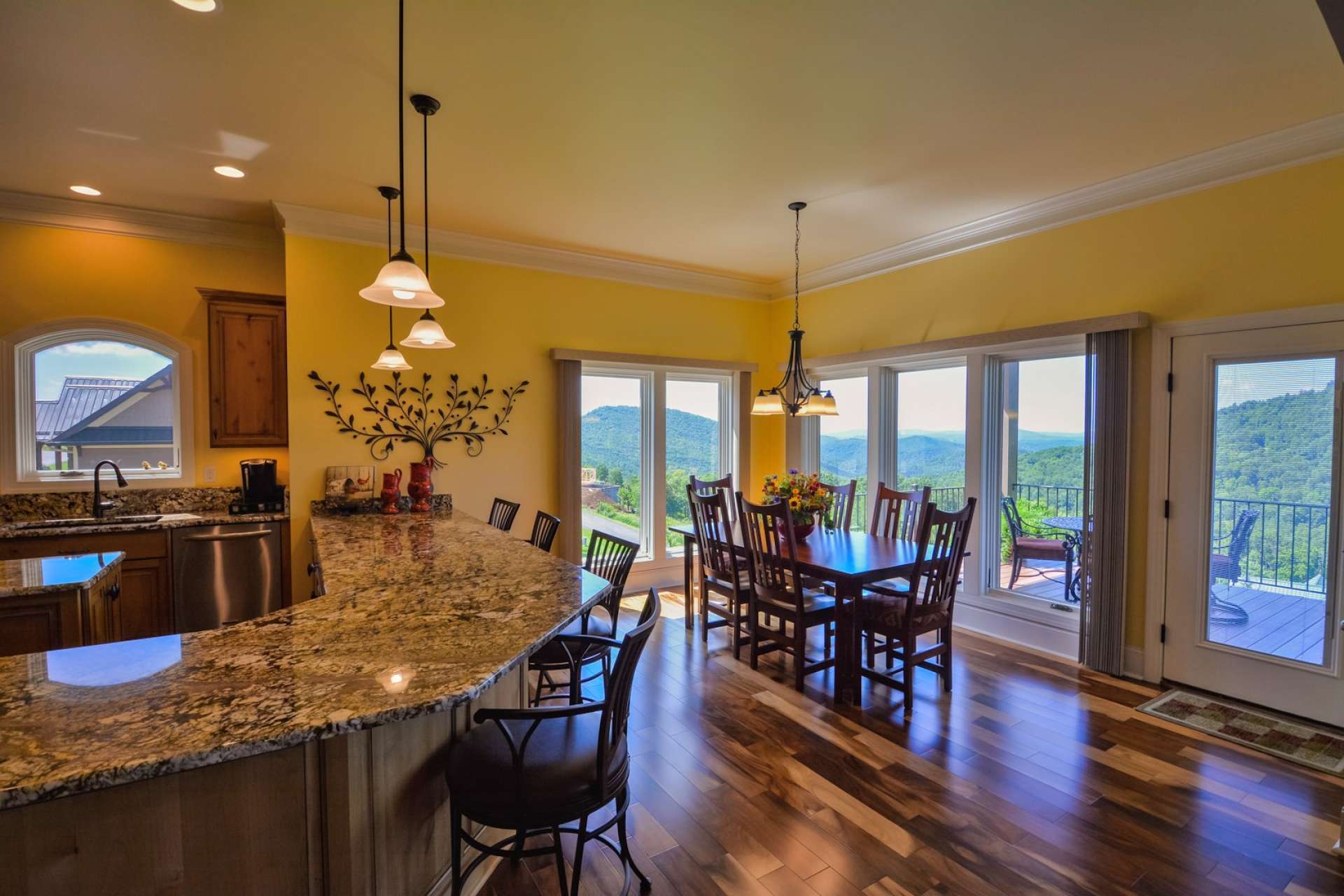 The open floor plan provides a bright, airy and spacious flow to the home. The dining area is positioned in the corner near the kitchen and offers large casement windows on two sides to enjoy the view and the natural light. This is also direct access to the back deck. Note the gorgeous acacia flooring which extends throughout the home, with the exception of the laundry and bathrooms.