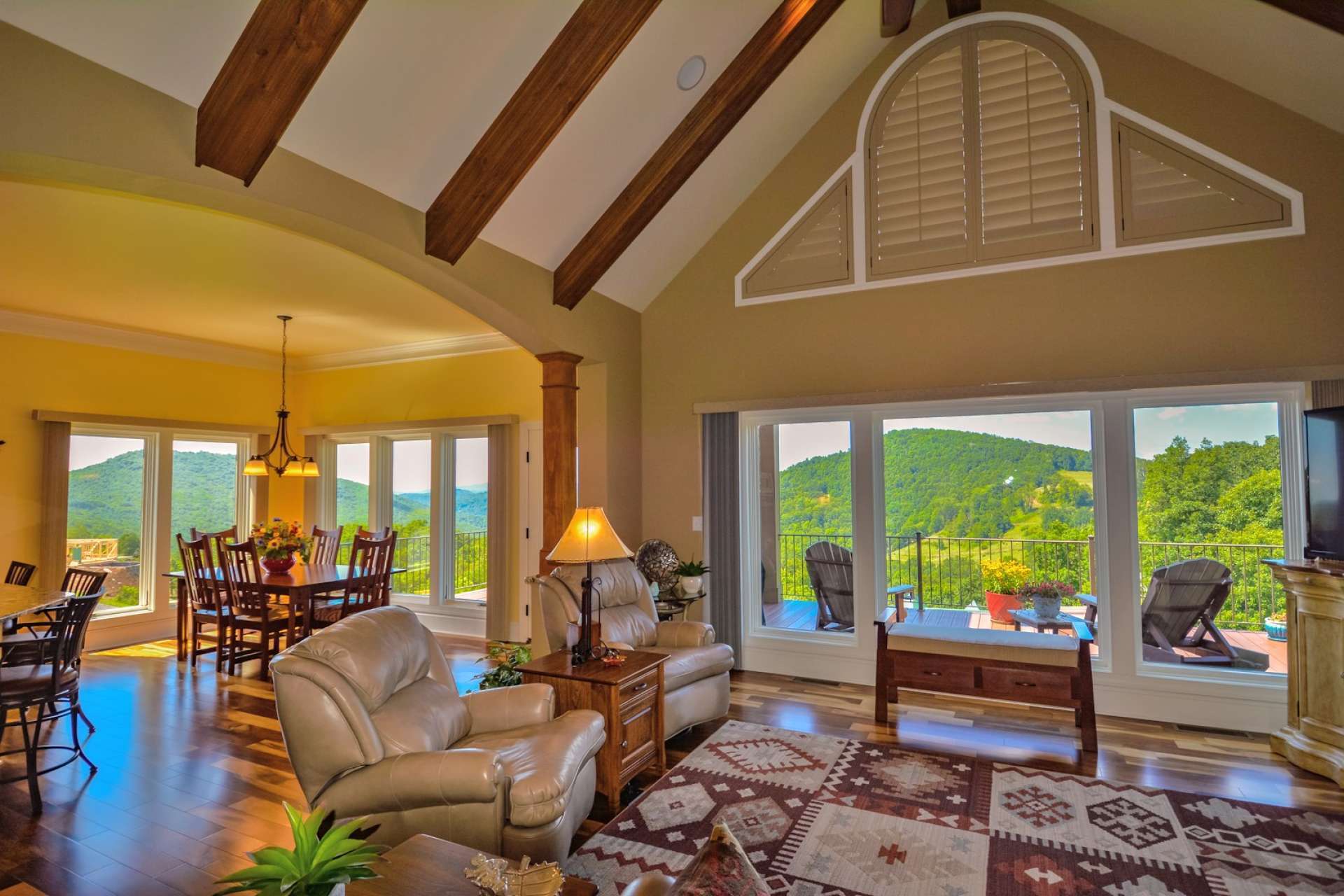 As you enter the home you'll step into an expansive great-room with vaulted cathedral ceiling with exposed beams and large rock fireplace with gas logs for ambiance and convenience. Extra wide windows frame the dramatic view beyond.