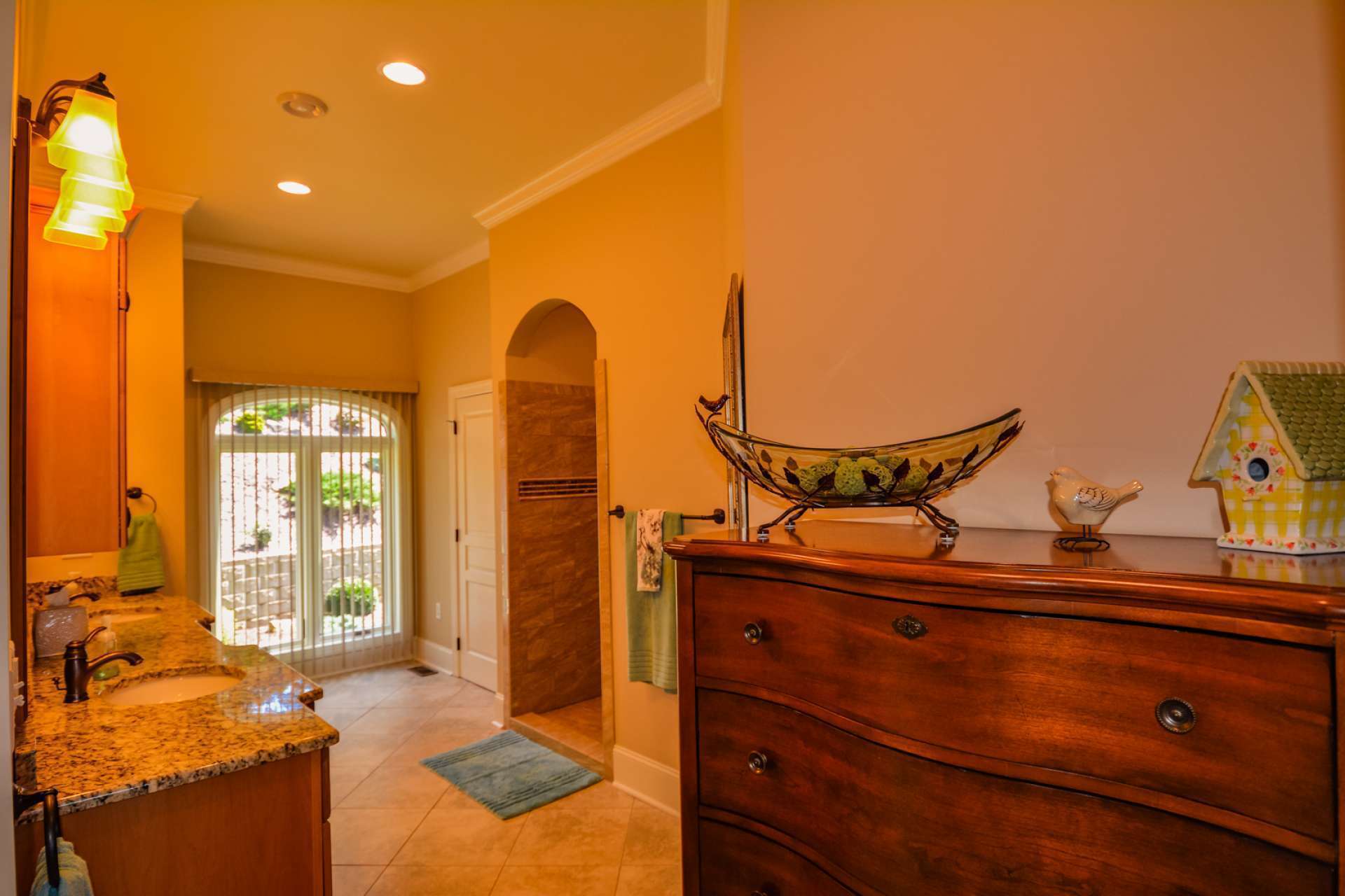 The gorgeous luxury master bath has a granite double vanity and a big window for natural light. An enormous walk-in shower welcomes you through an arched entryway. The shower includes separate handheld showerheads with diverters. Even the home's elongated, high-profile toilets are upgraded with soft close seats. The cabinetry is custom knotty alder.