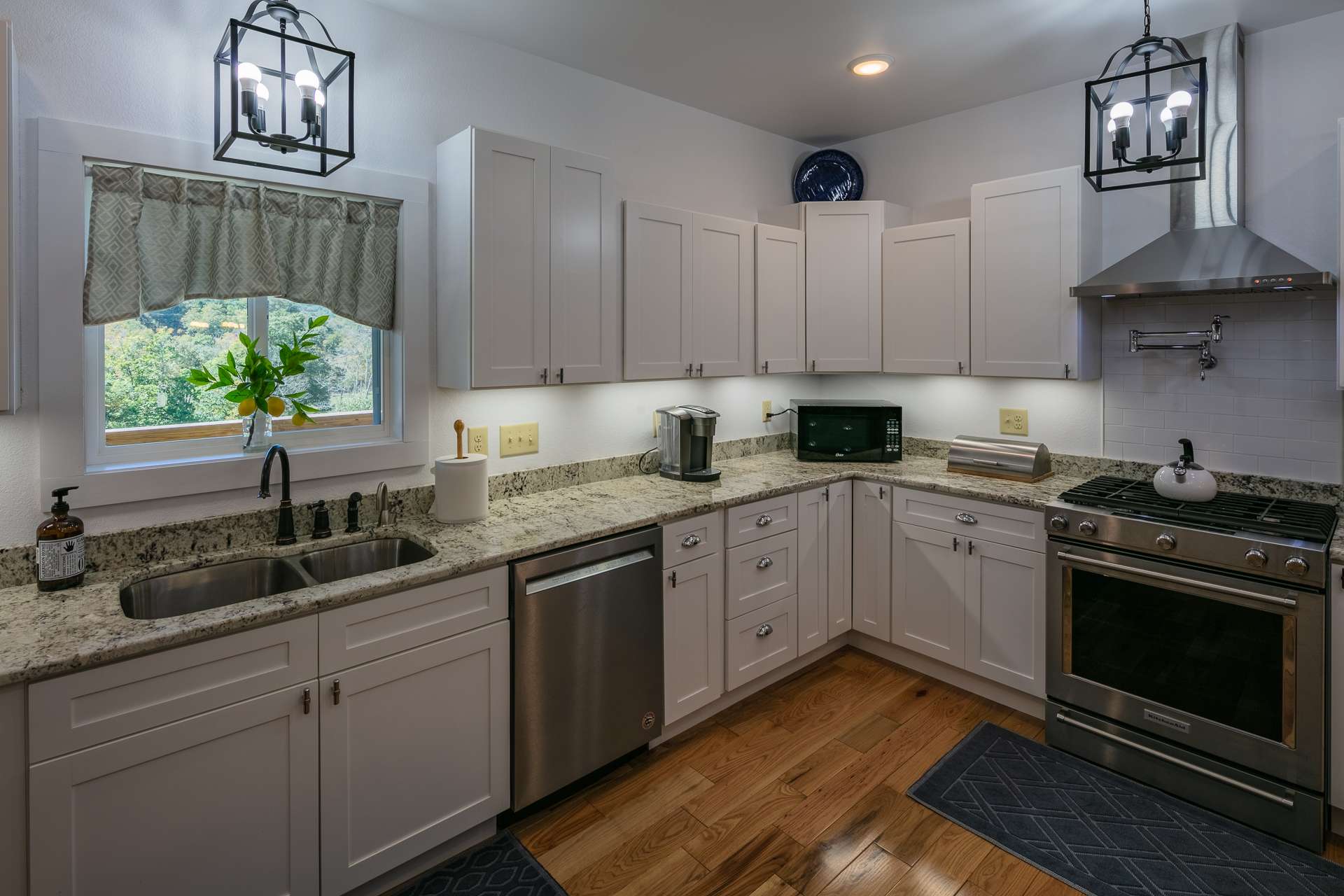 This designer kitchen featuring stainless appliances, including a gas range with pot filler, is perfect for the creative gourmet.