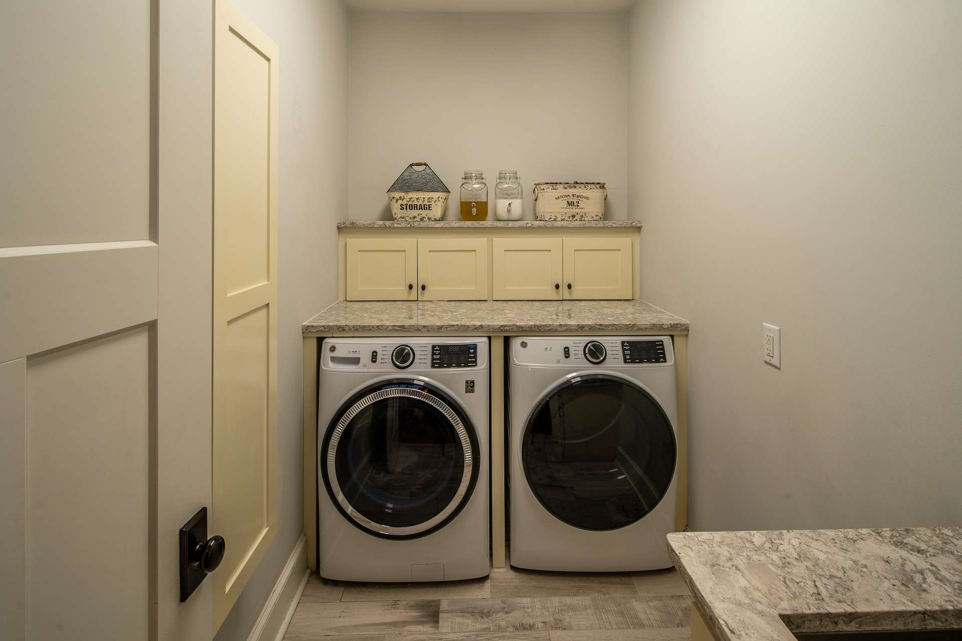 The laundry room is located on the main floor and provides storage cabinetry and a full sink.