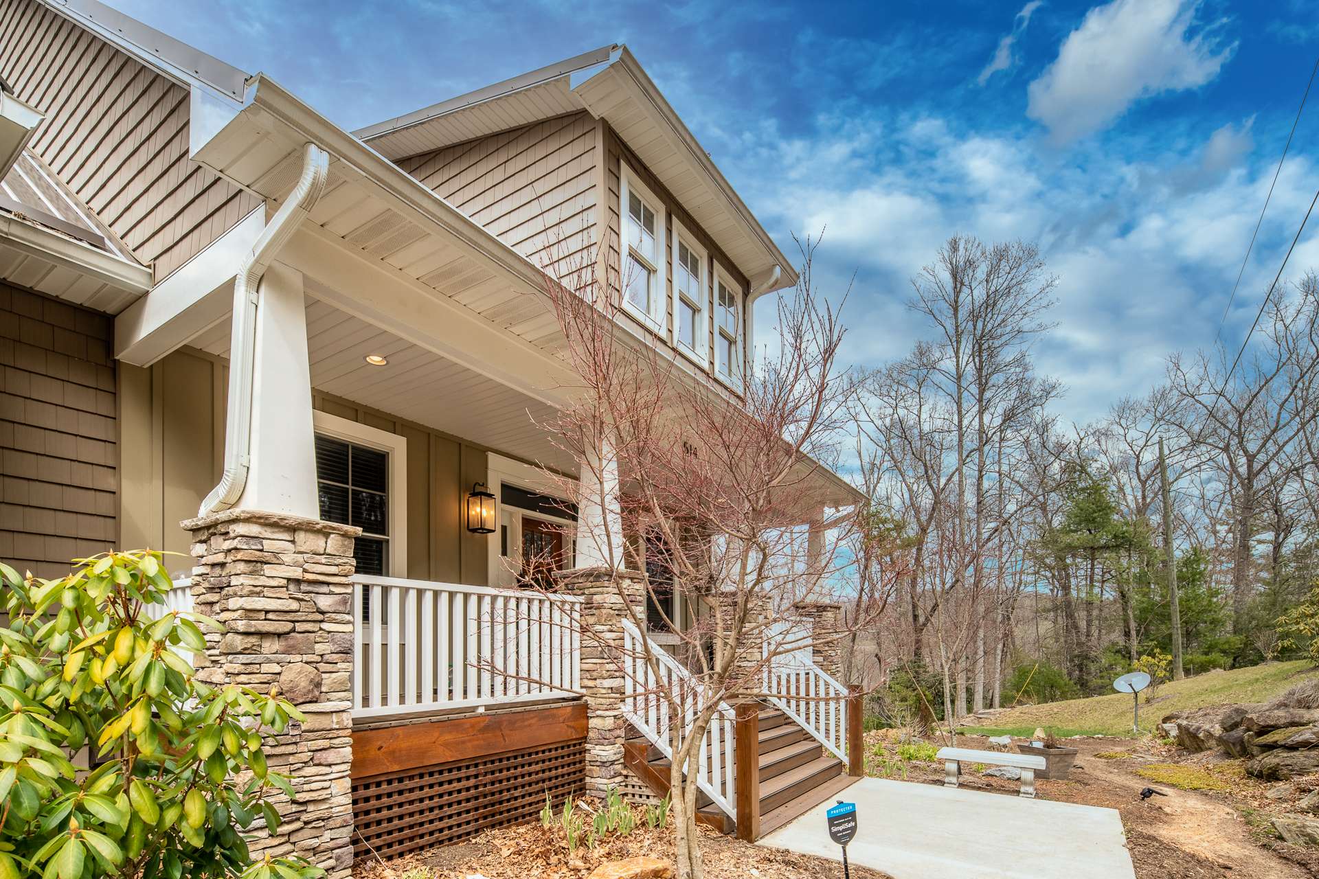 A covered front porch invites all to  enter this custom home and experience mountain living at its finest.