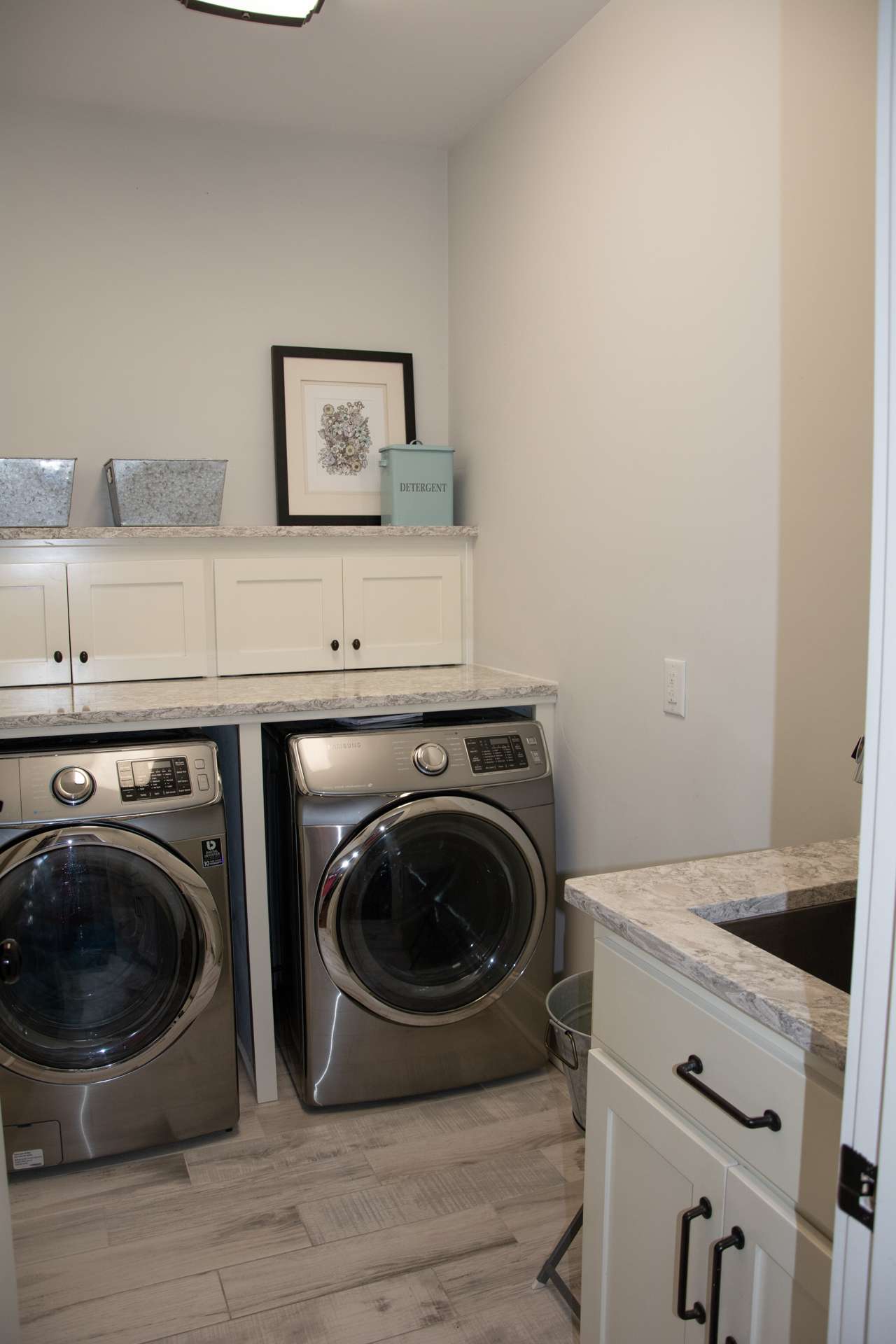 The laundry room is located on the main floor and provides storage cabinetry and a full sink.