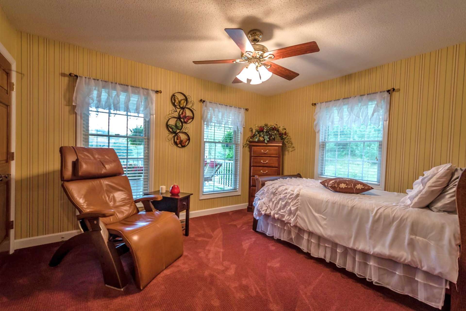 The second guest bedroom on the main level offers a carpeted floor and private bath with walk-in shower.