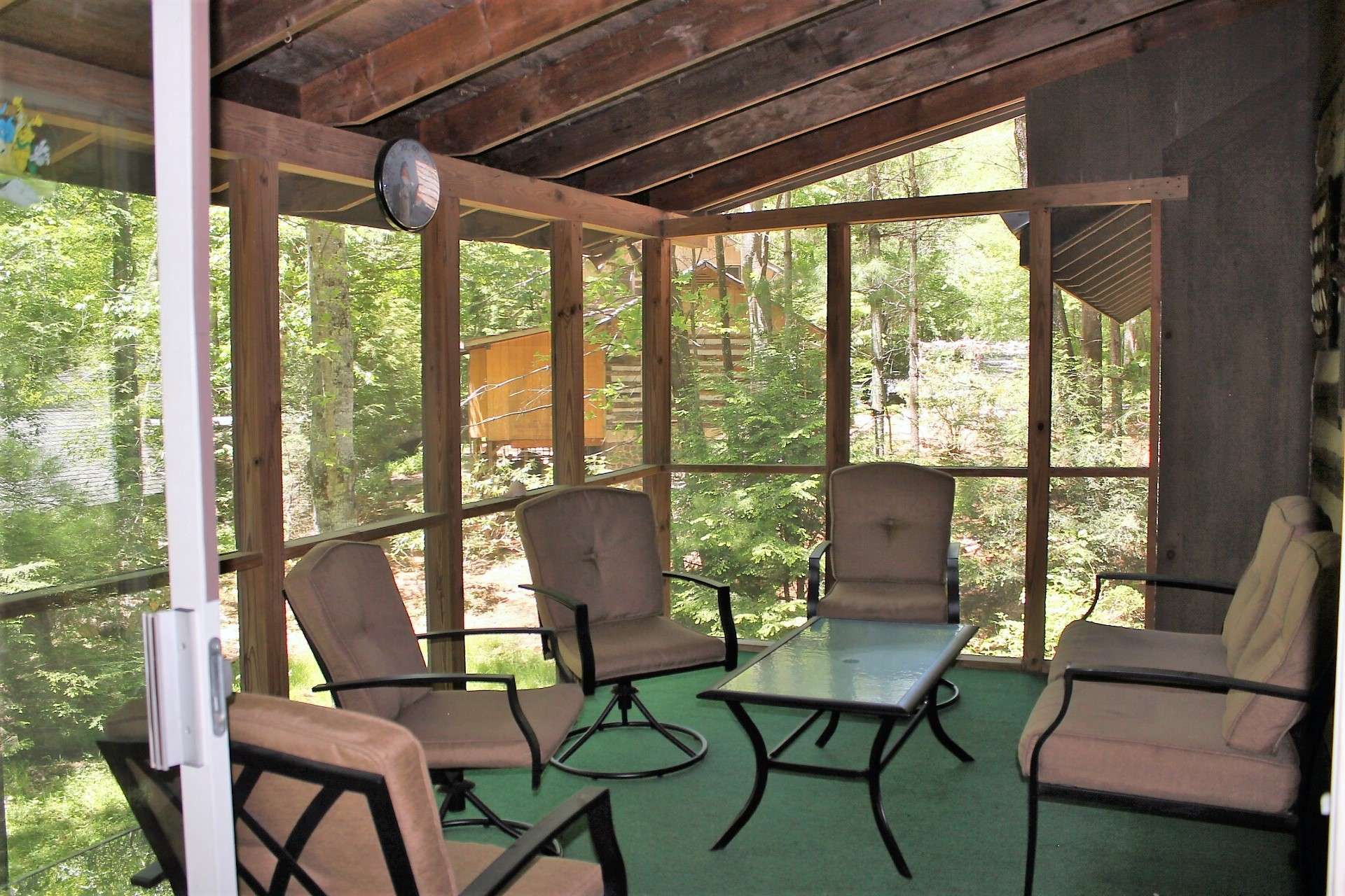 Enjoy the cool summer breezes while entertaining friends on the covered screened porch with easy access to the kitchen.
