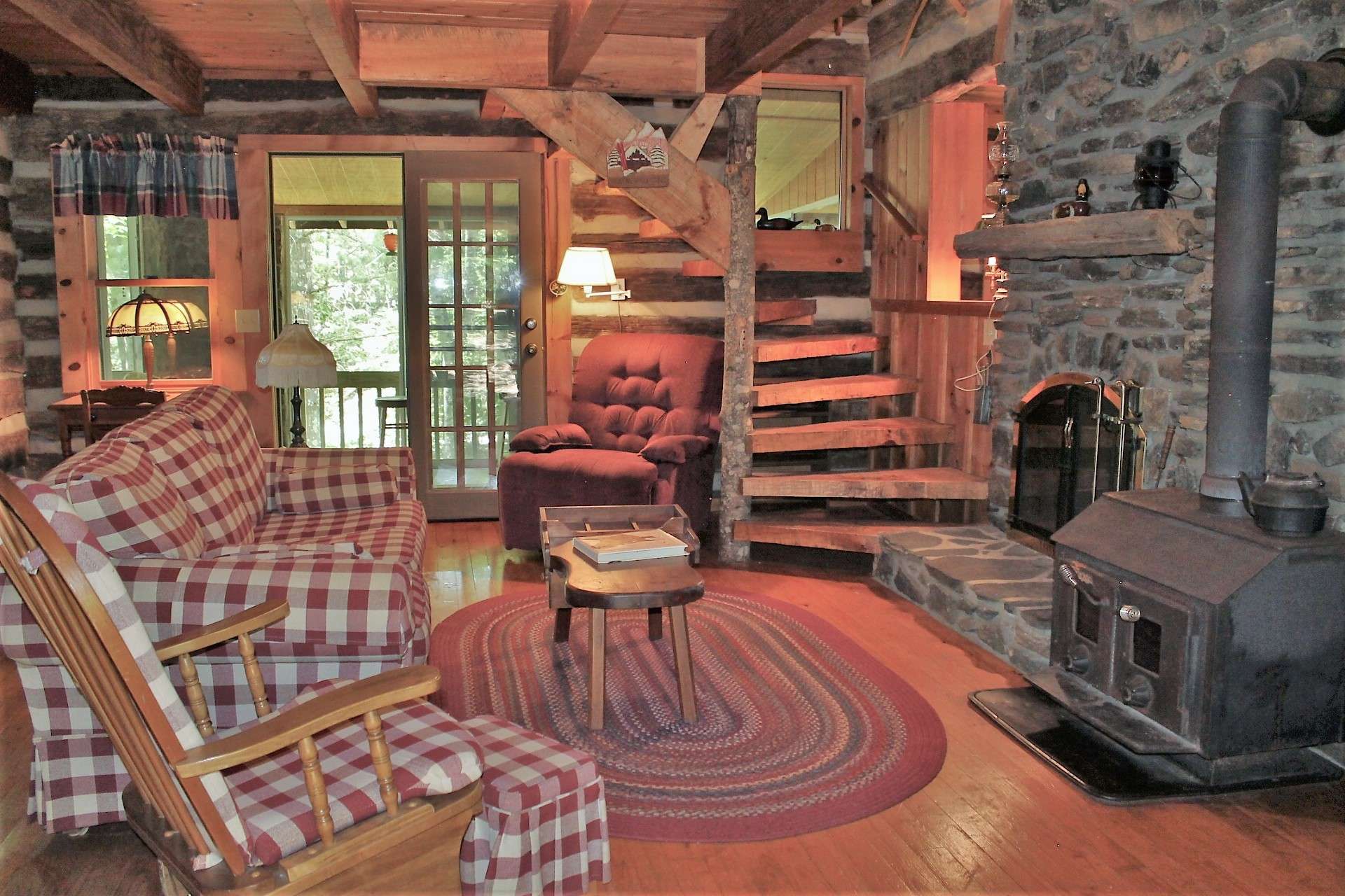 Welcome to this cozy and inviting family room with hand hewn stairs leading to the second level.