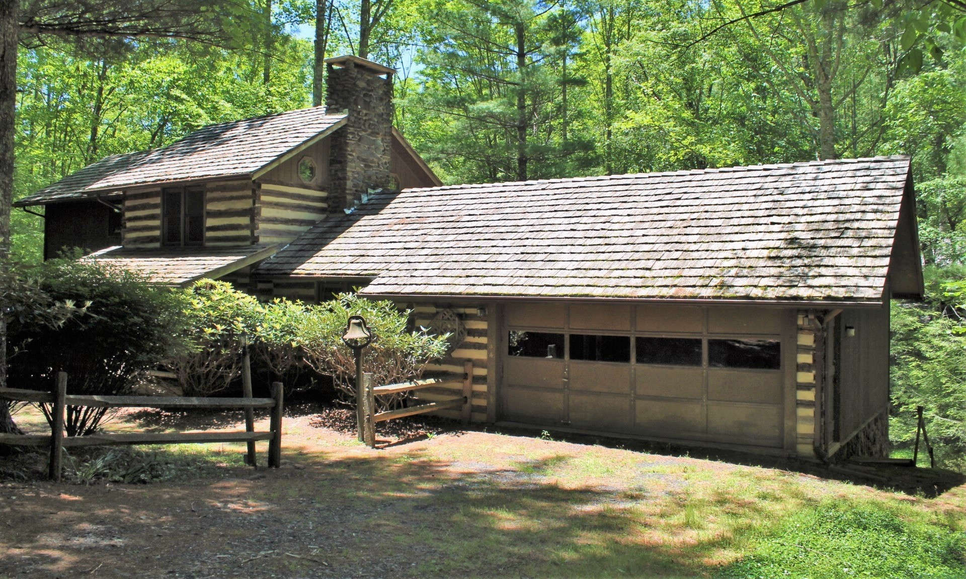This charming antique-styled log cabin with 3 bedrooms, 2 baths and an attached 2 car garage situated in a park-like setting with bold rushing creek is located in the Stonebridge community, a highly sought after rustic log home community in the Todd area of Southern Ashe County.