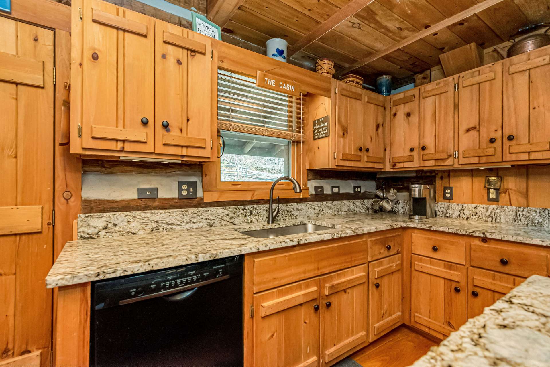The kitchen showcases granite countertops complementing the hand-crafted wood cabinets, and stainless steel appliances.