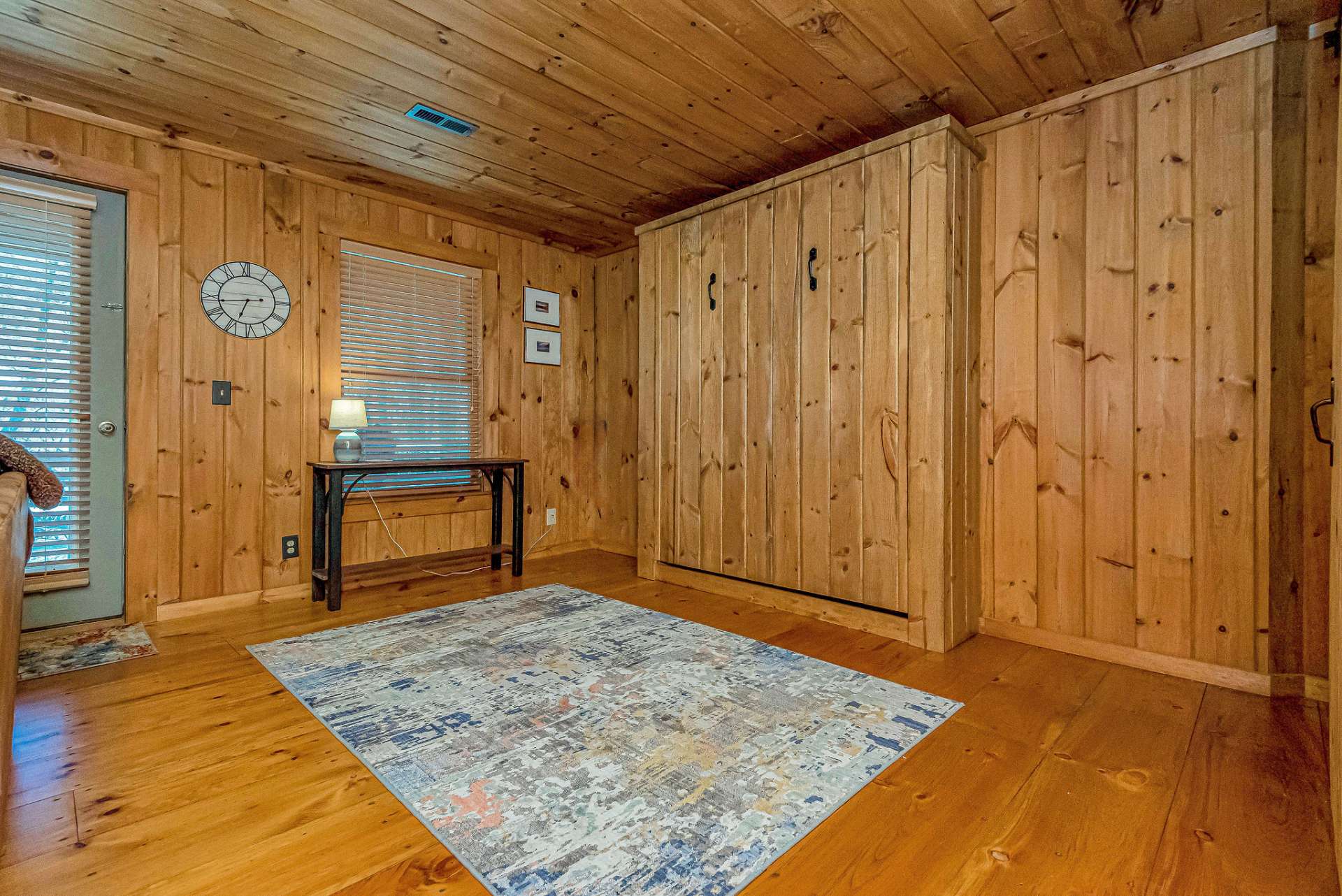 Murphy bed folds up and leaves space for a game table or exercise equipment.