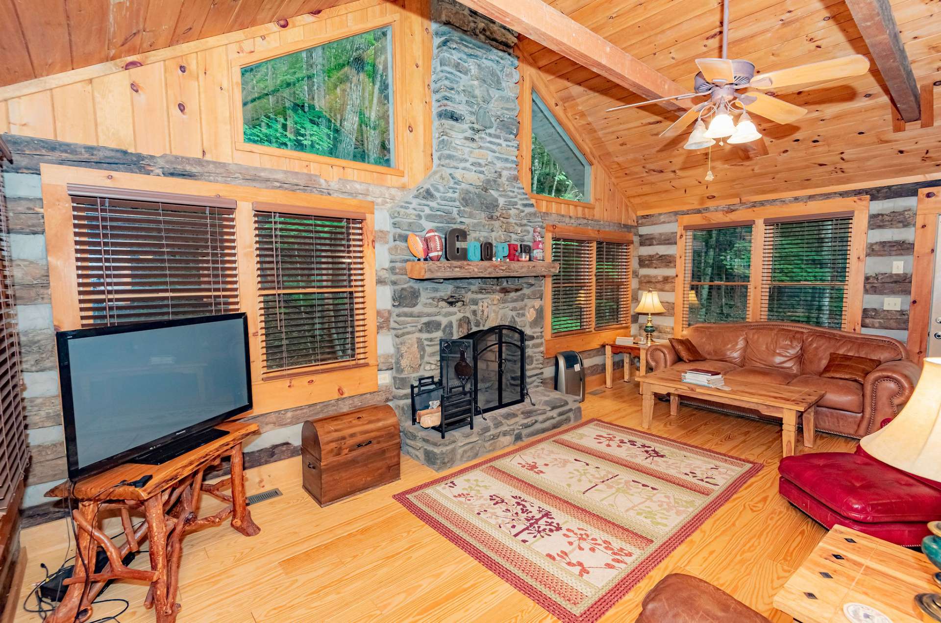 This space offers plenty of windows for natural light, wood floors, and a massive floor to ceiling stone fireplace.