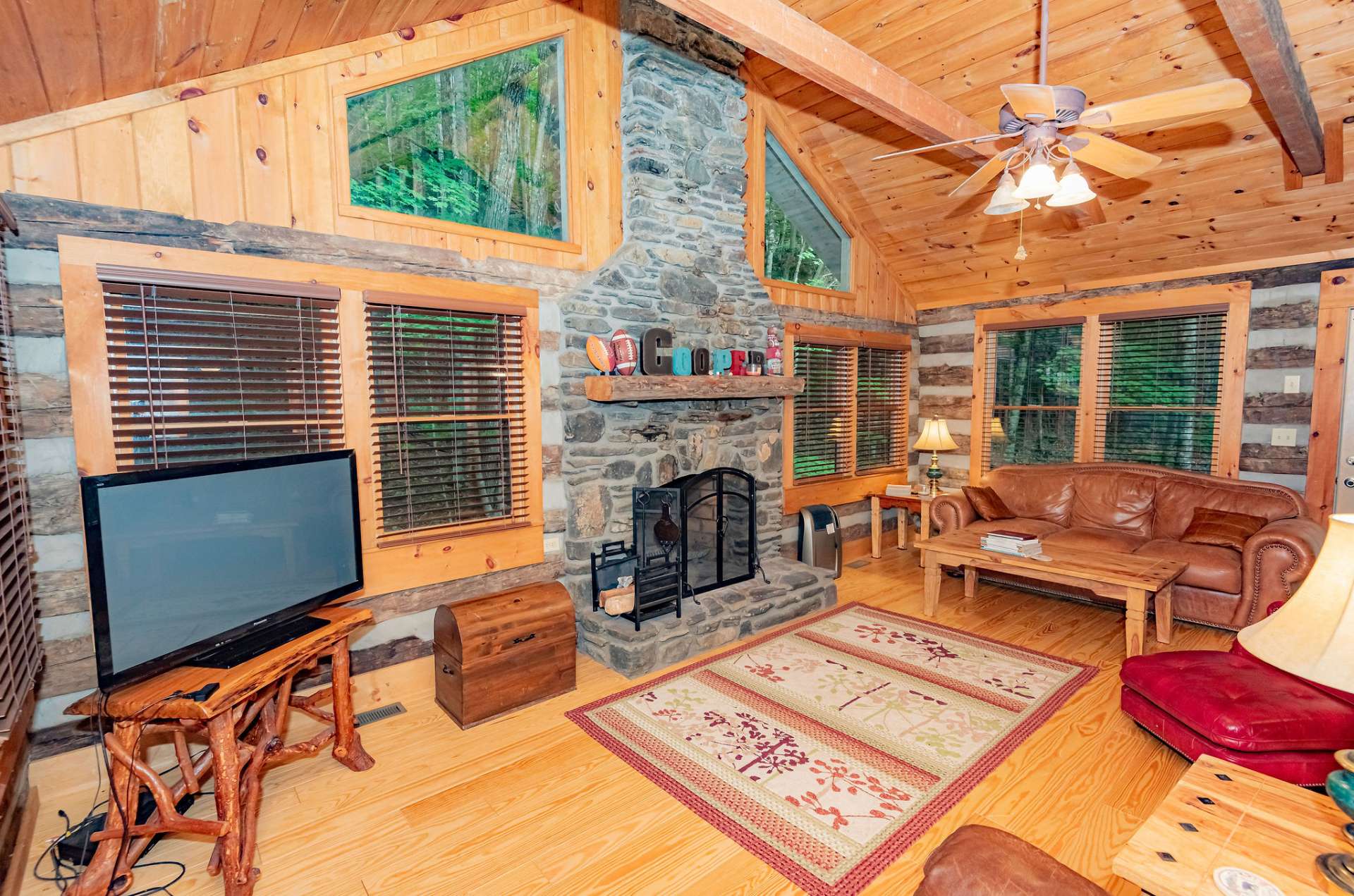 This space offers plenty of windows for natural light, wood floors, and a massive floor to ceiling stone fireplace.