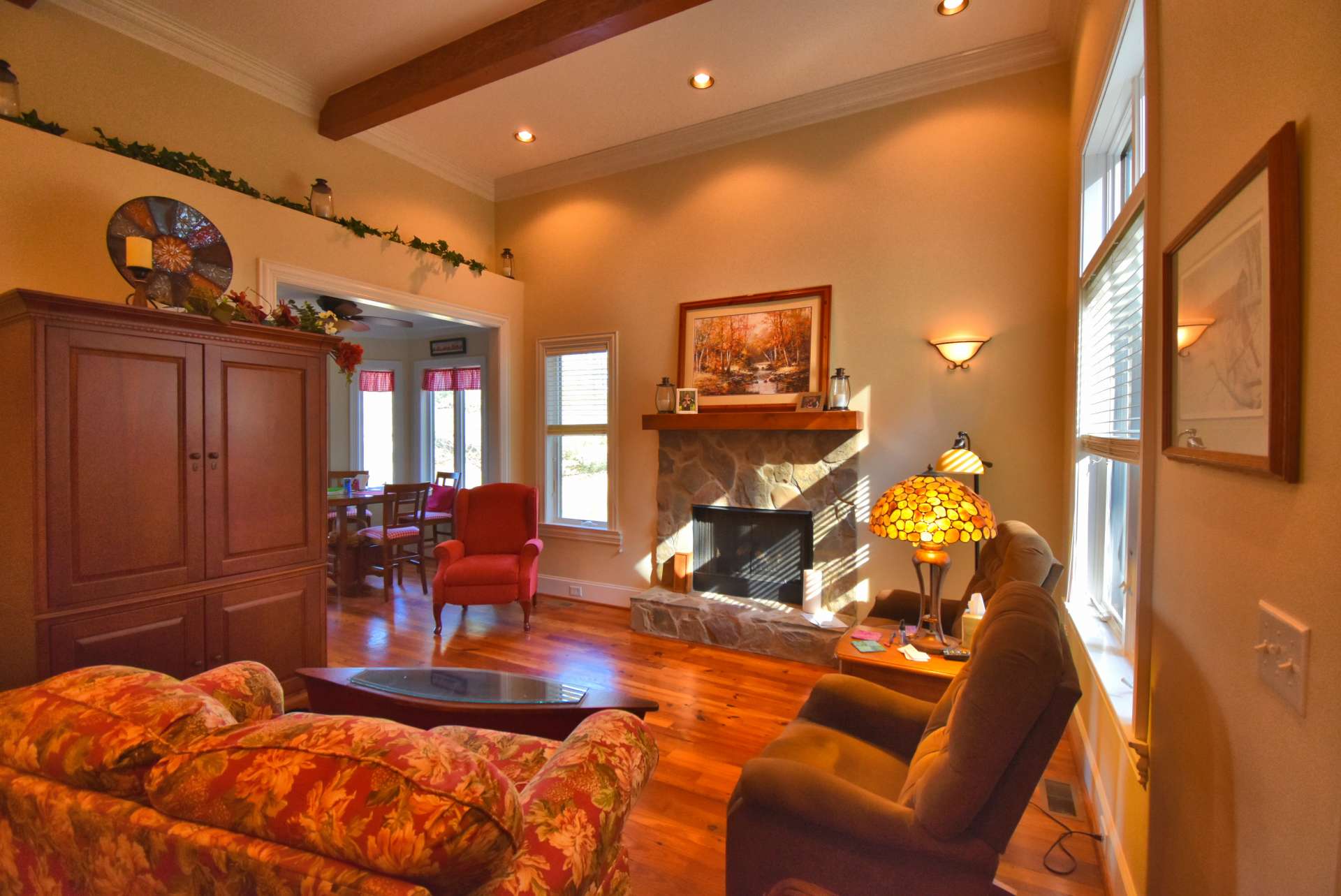 A stone fireplace with gas logs in the living area sets the pace for a quiet and peaceful evening. Notice the unique flooring reclaimed from an Ashe County tobacco barn. Another unique feature is the 12' ceiling and the "shelf" along the interior wall.
