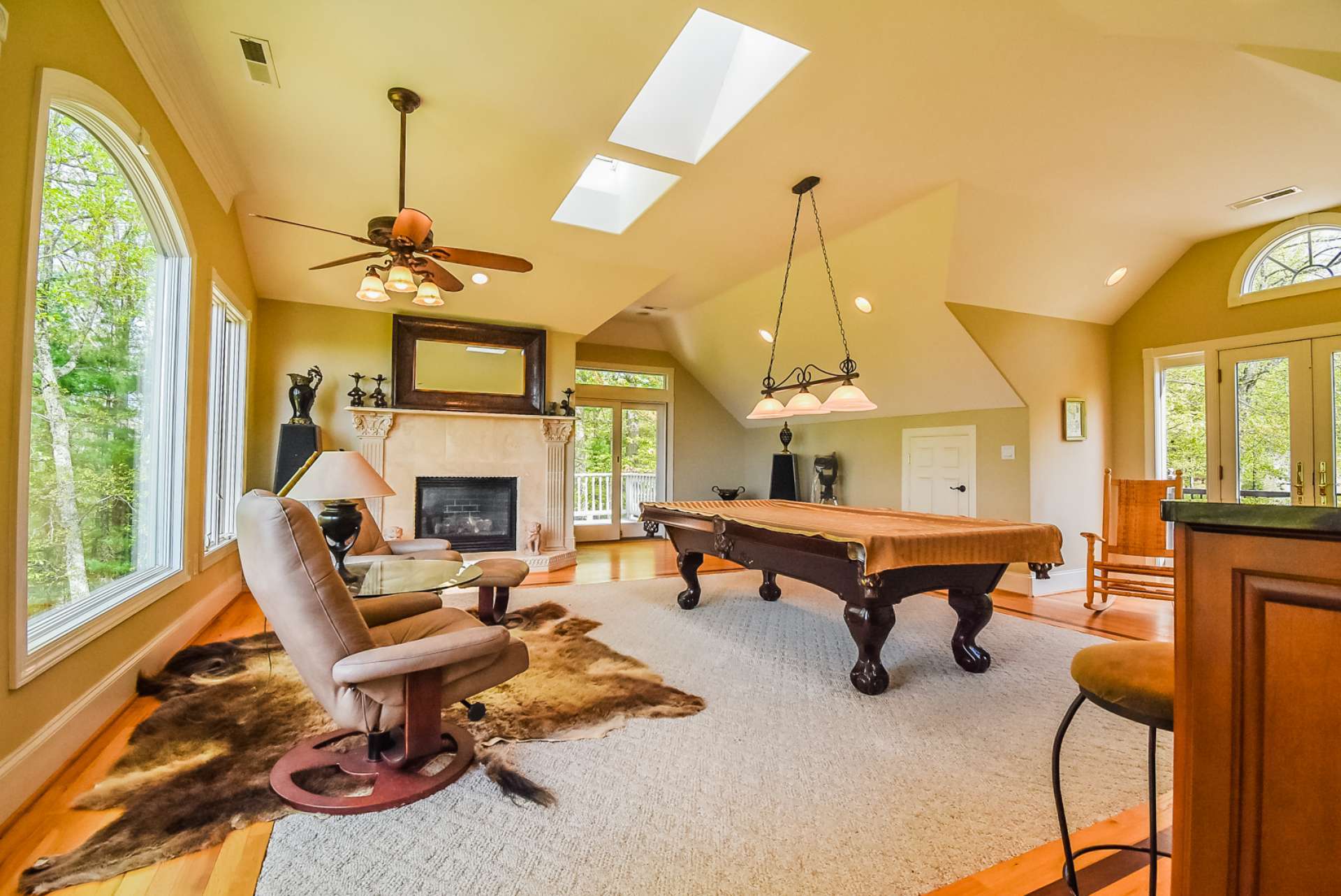 The second level features a large game room with the gas log fireplace, skylights, private deck, and full bath.