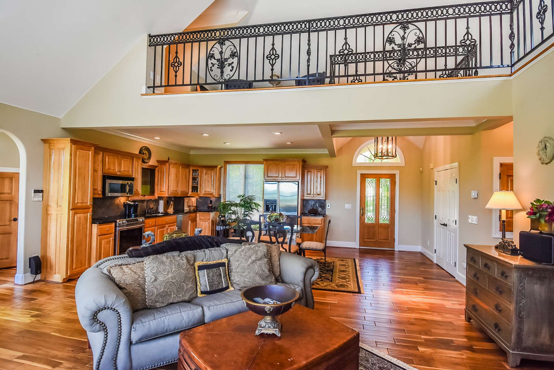 The open floor plan allows for easy flow when entertaining indoors. Notice again the wrought iron, arched doorway, and other custom details.