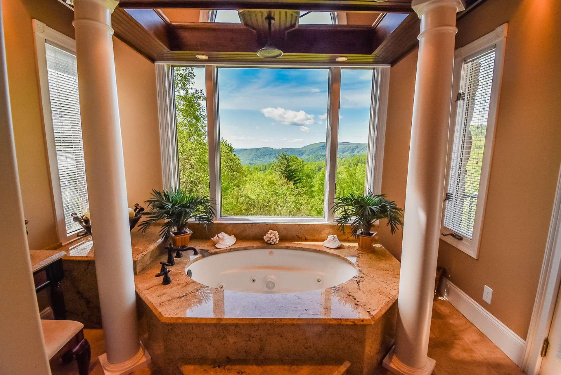 This luxurious master bath provides a spa-like experience with its jetted tub with rain shower head surrounded by stunning long range mountain views.