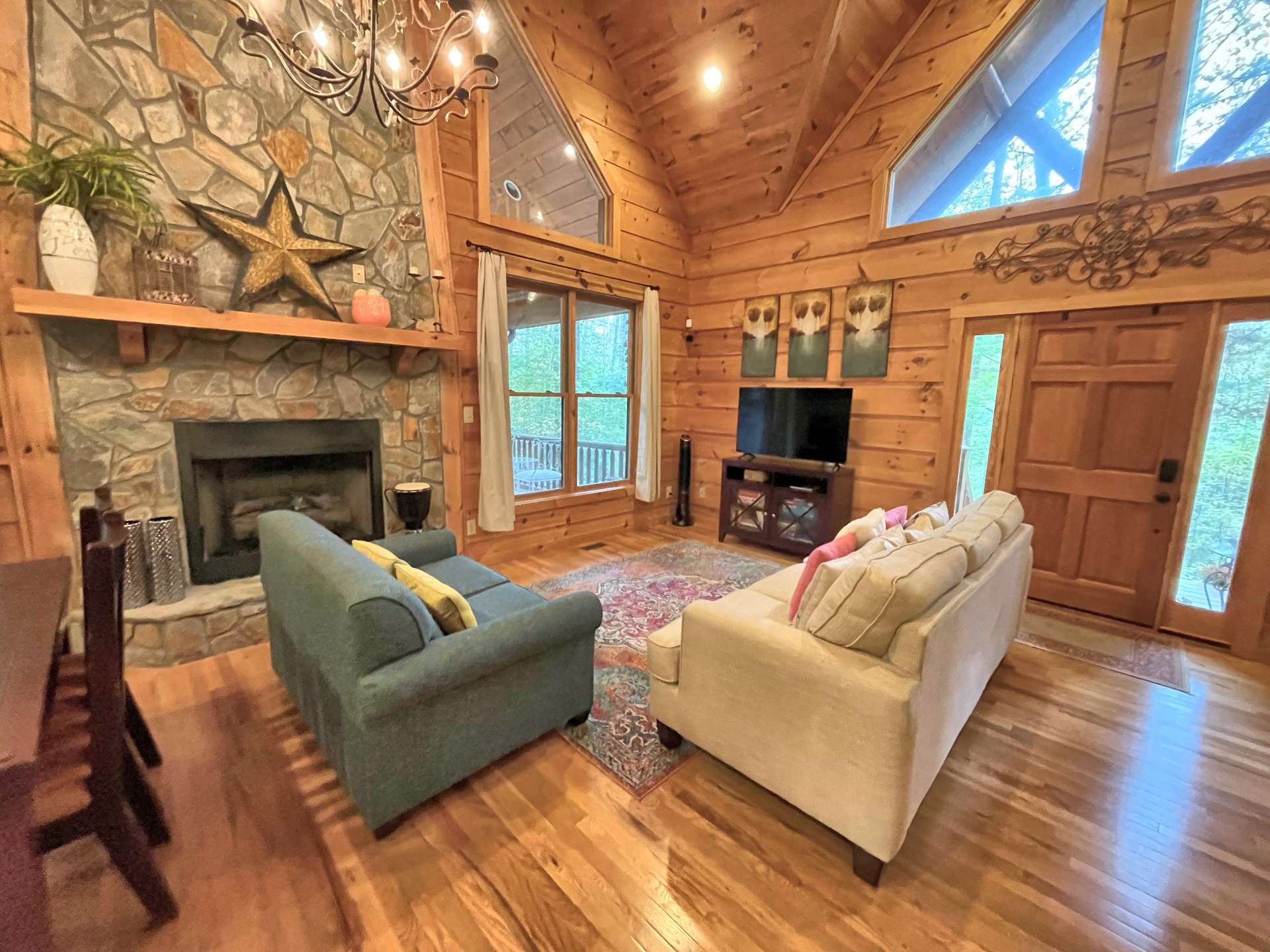 Vaulted living room area with fireplace and lots of windows for natural light.