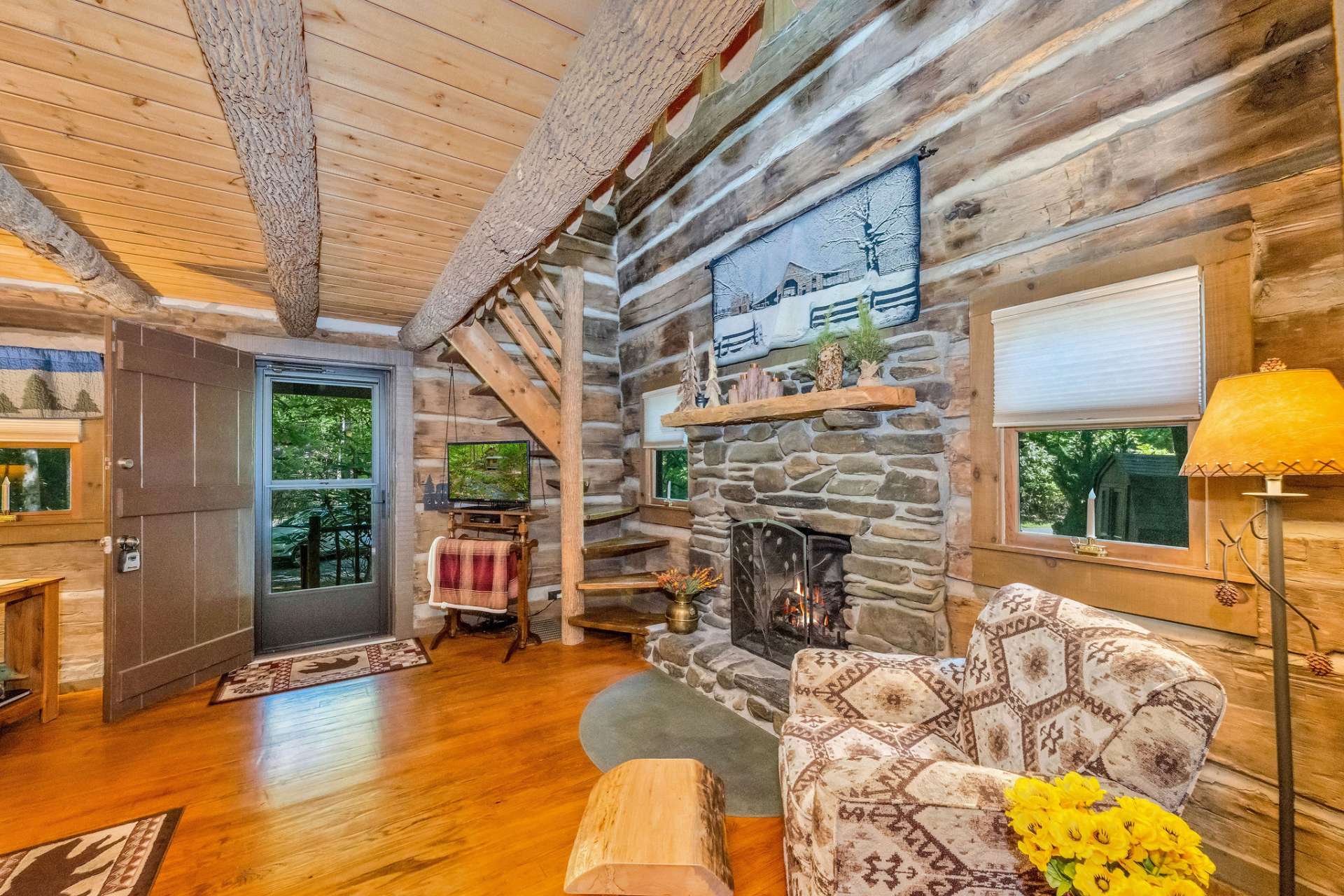 A stone fireplace welcomes you to enjoy true mountain cabin living.