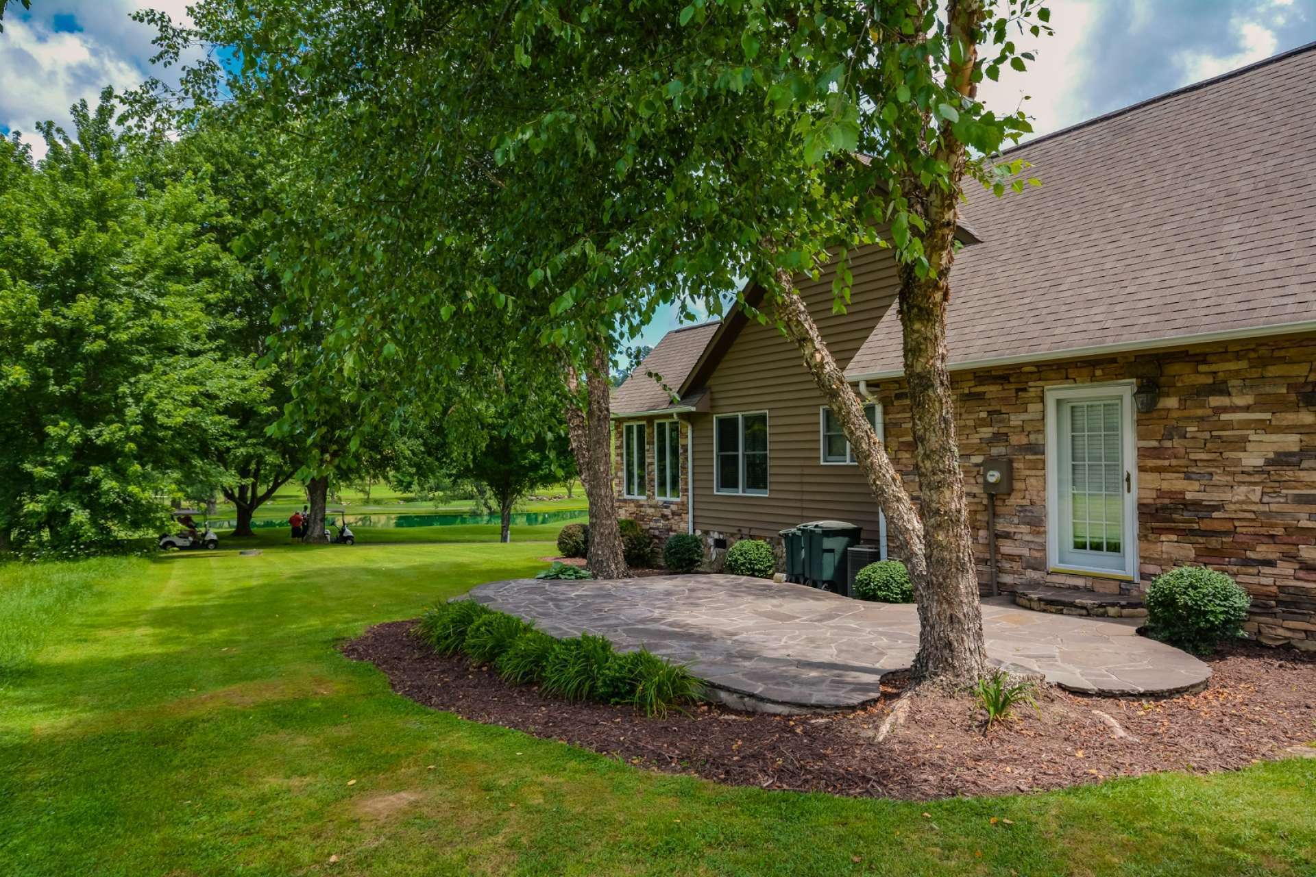 In addition to the deck and lawns, this stone patio offers additional outdoor dining and relaxation space.