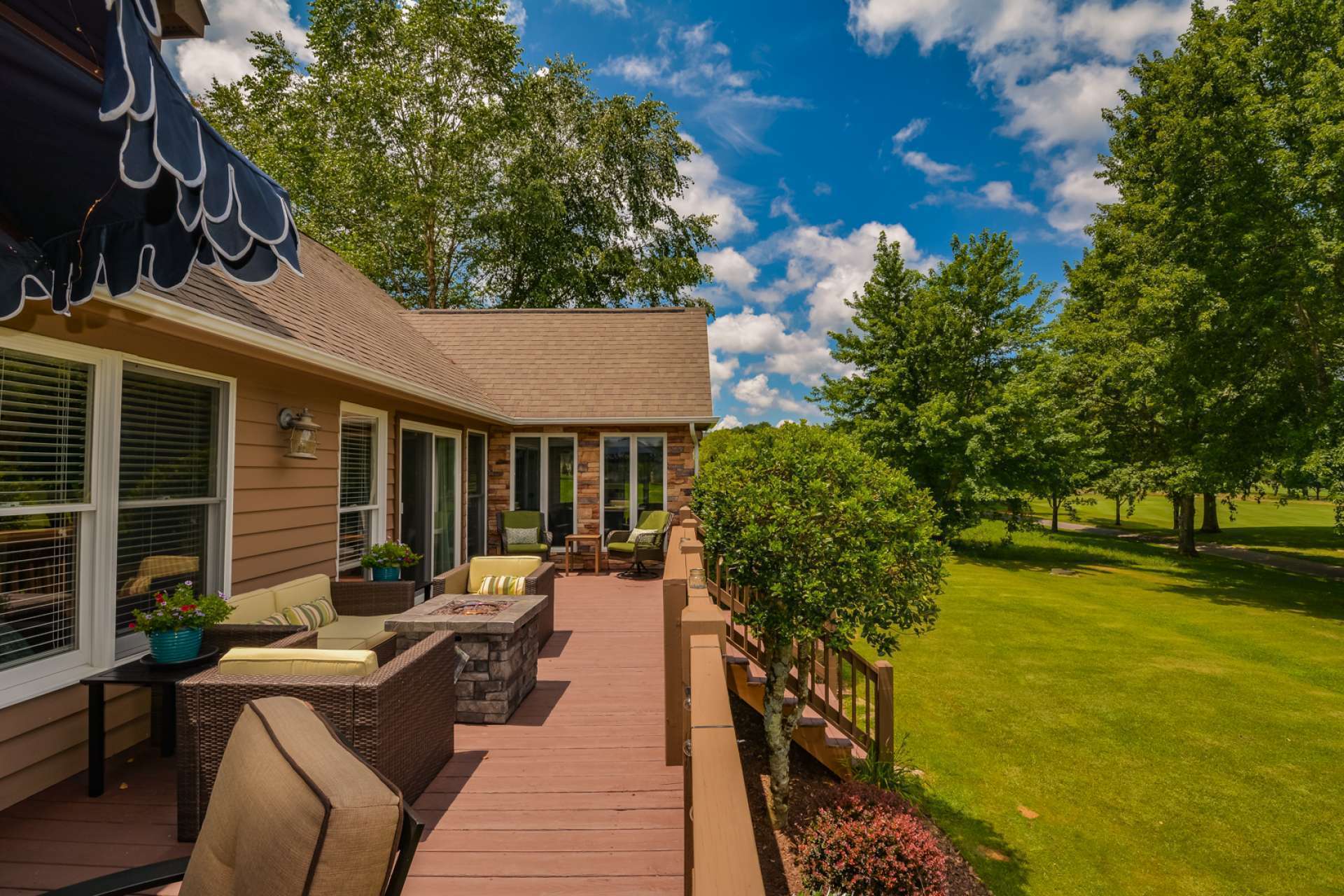 An open spacious deck overlooking lush landscaping and the pond creates an outdoor living area that is pure paradise.