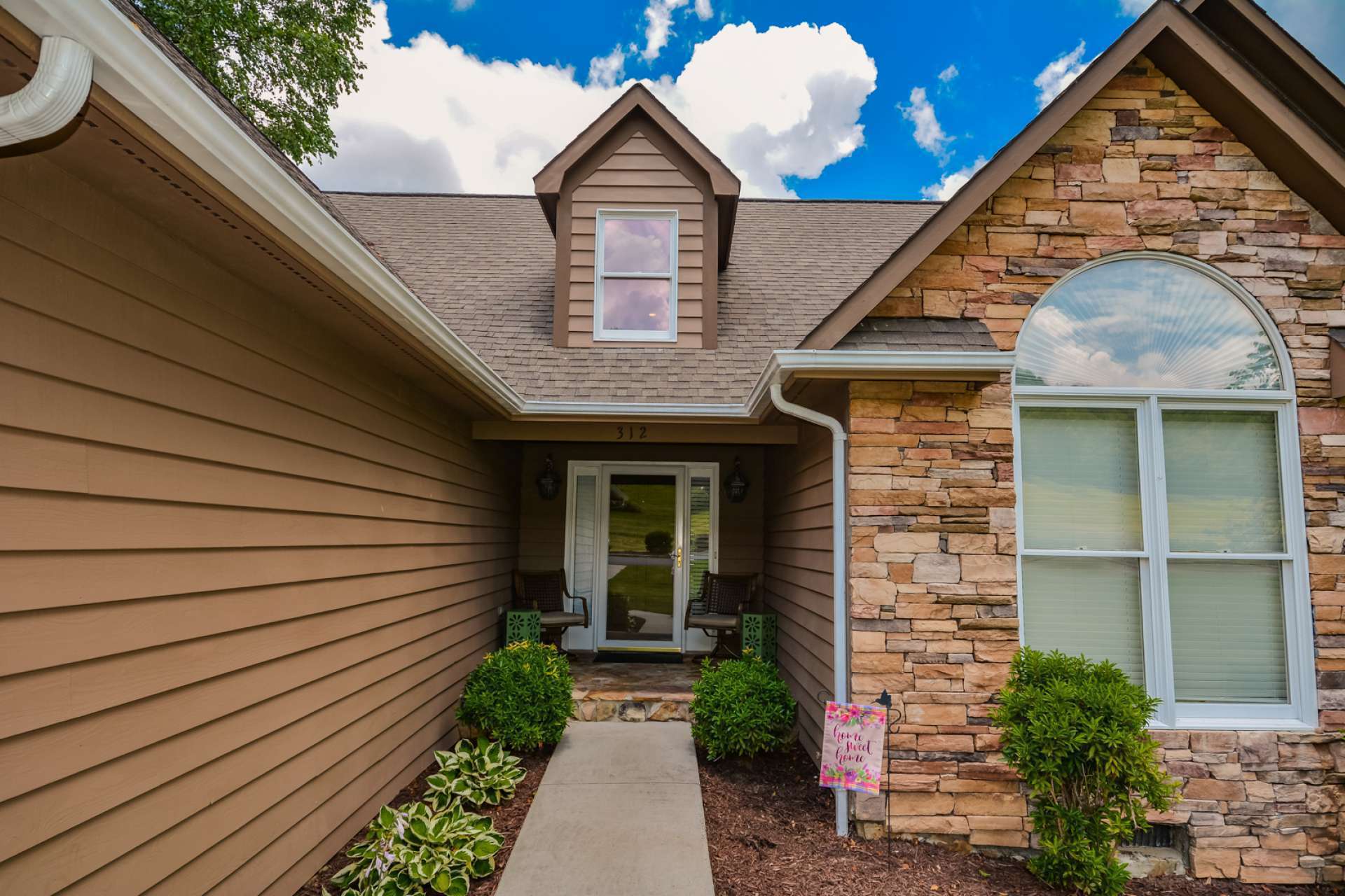 A paved walkway and covered porch welcomes you to enter the home and experience elegant and comfortable mountain living.