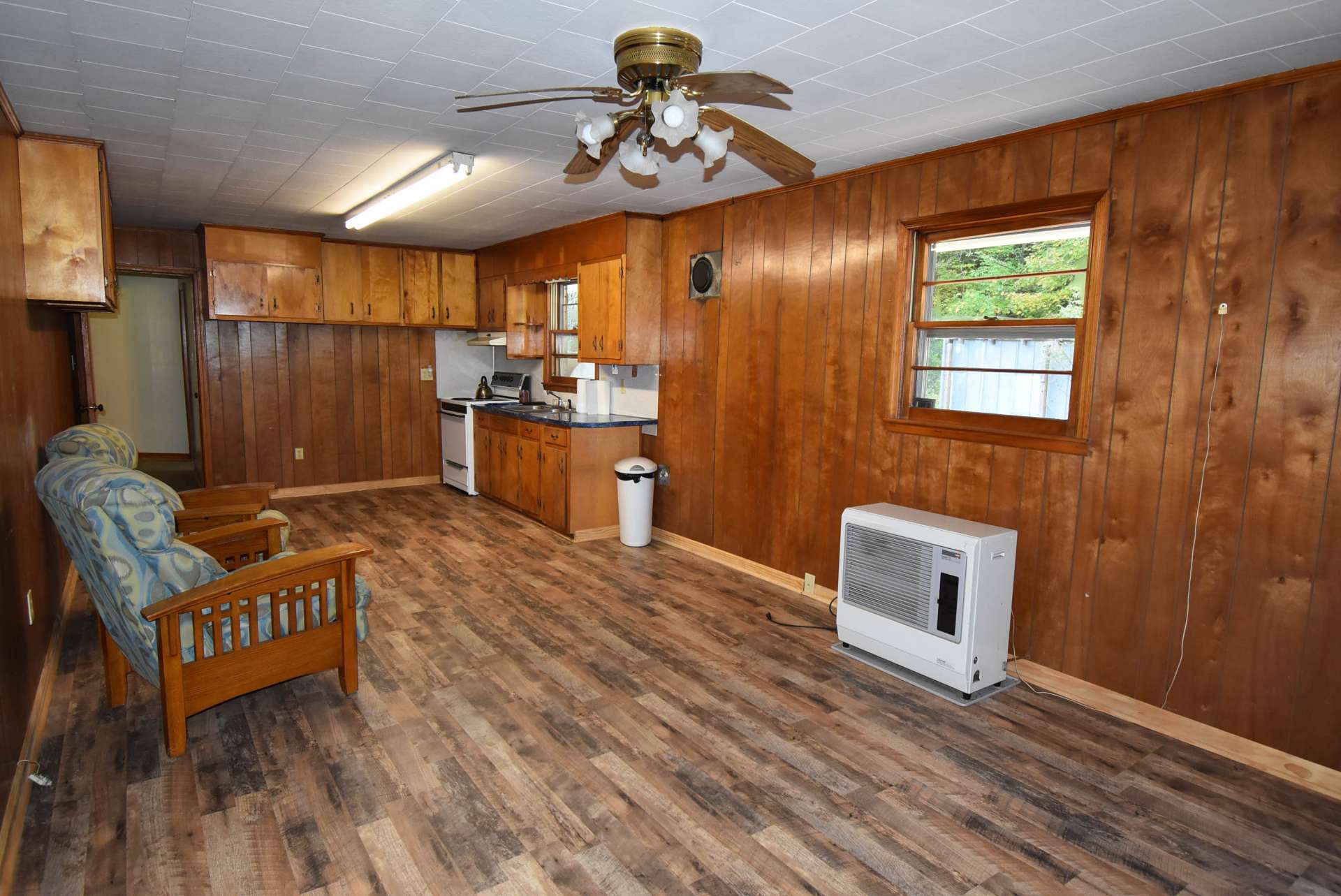 A large eat-in kitchen offers plenty of work and storage space.  Notice the new flooring  and there is also a flue, should you want to add a wood stove for added warmth.