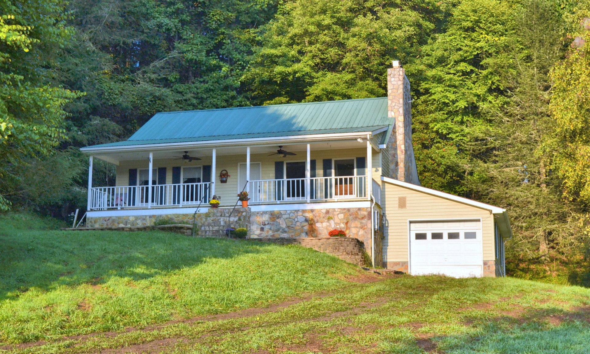 Enjoy the mountain views and the sights and sounds of Little Wilson Creek as well as a small waterfall from the covered front porch of this charming cottage