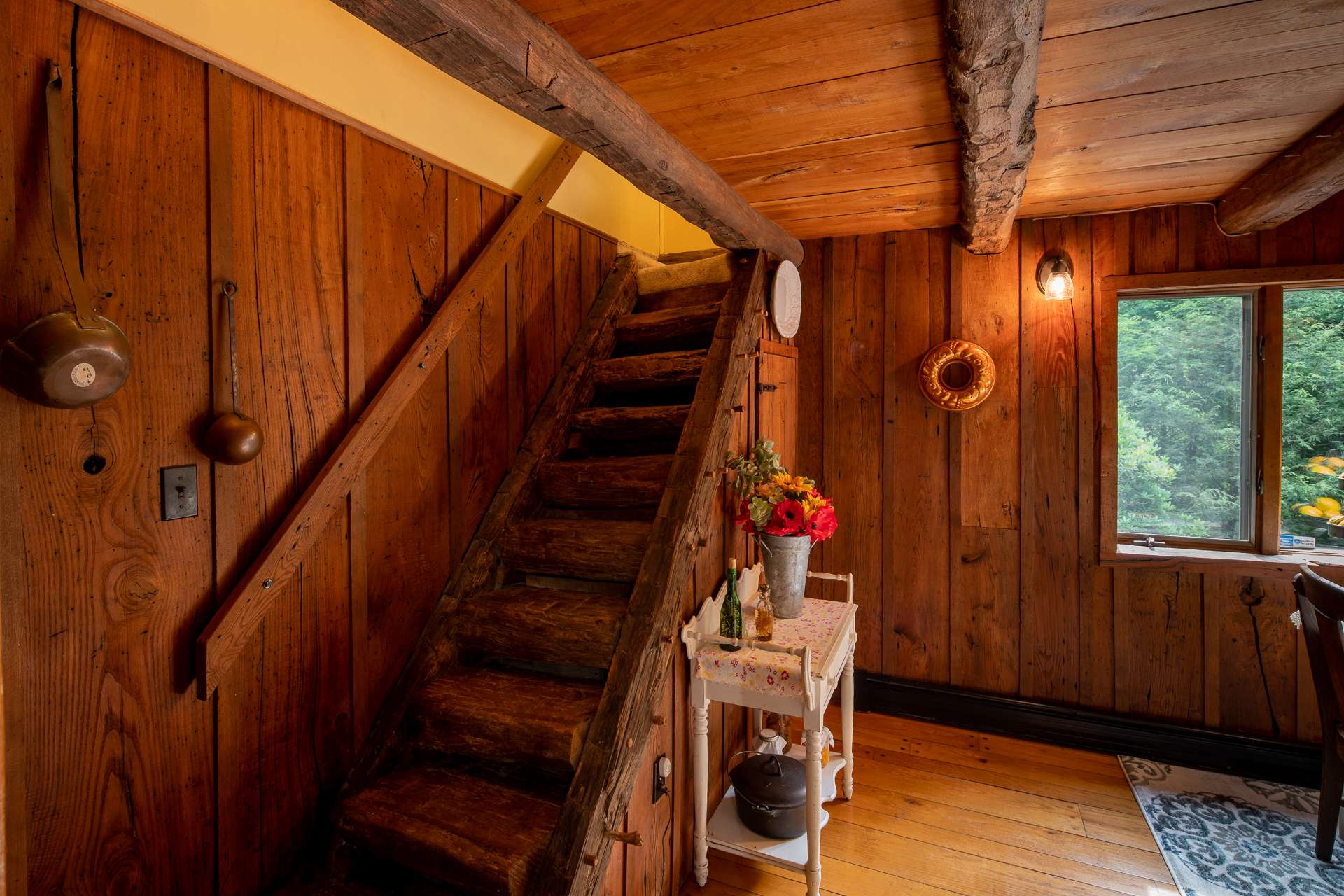 Original hand-hewn stairs leading to the second bedroom on the upper level.