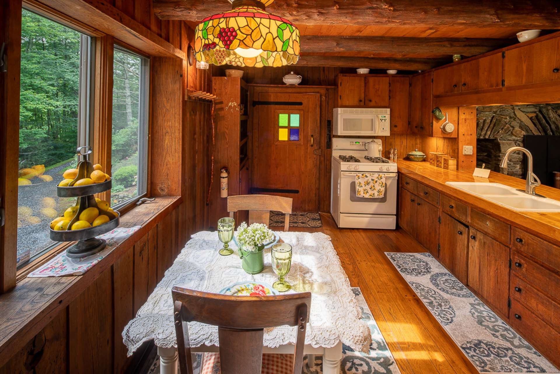 Enter the home through the front door with early 1800s stained glass into the kitchen with wormy chestnut cabinets and red oak hand pegged floors