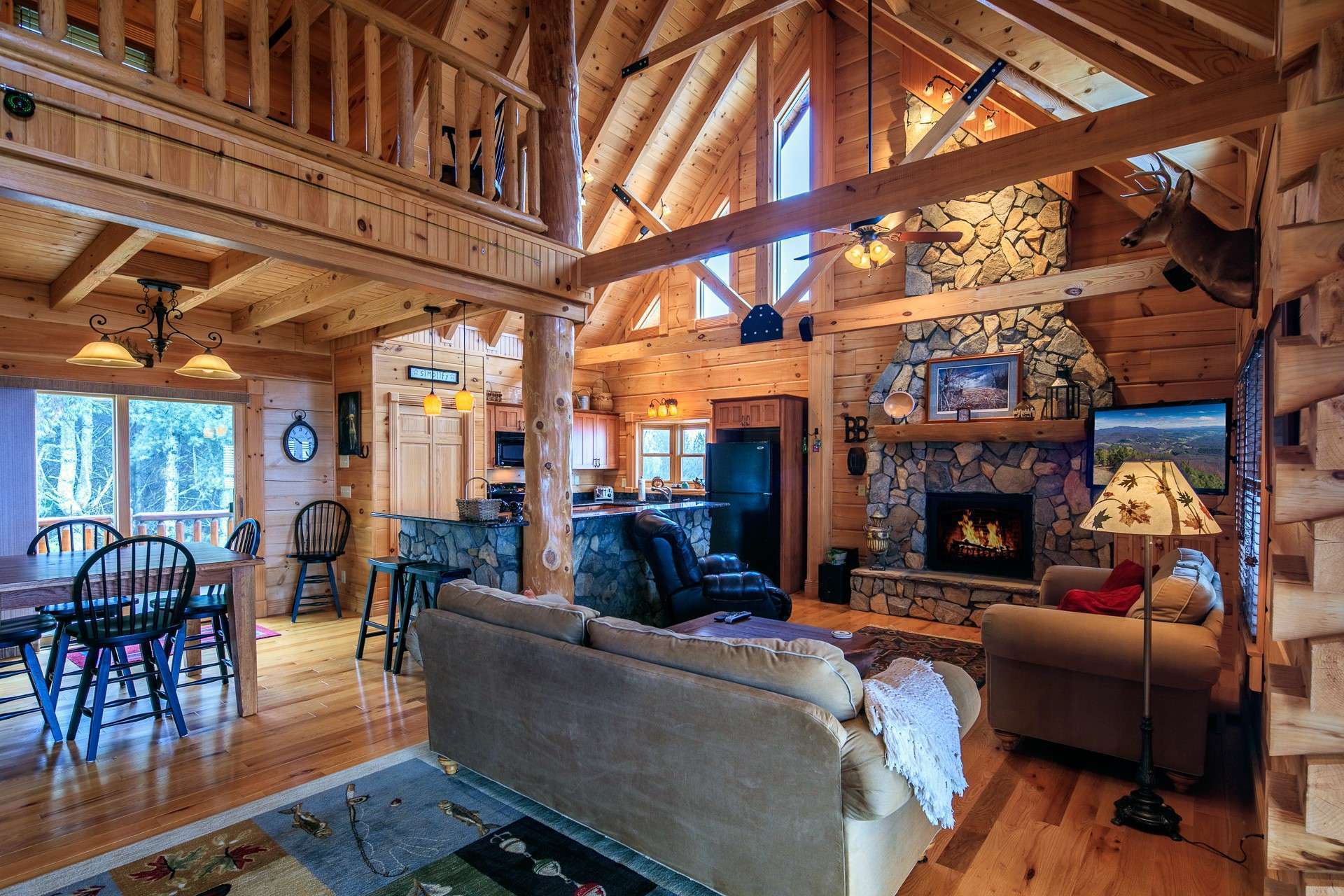 The main level offers an open great room with a soaring vaulted ceiling, stone fireplace with gas logs installed,(could be converted back to wood-burning if desired.) wood floors, stunning architectural accents and quality custom appointments.