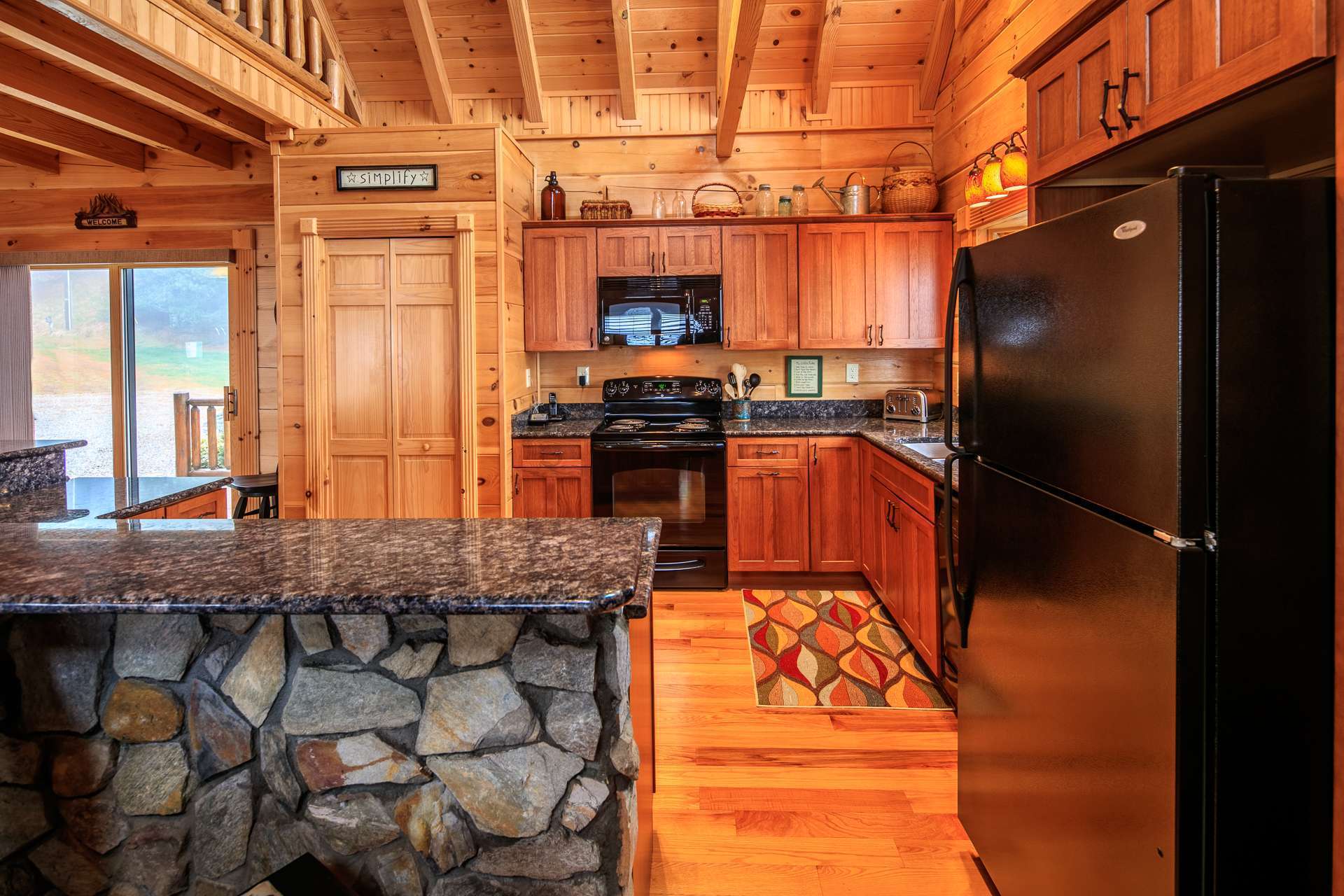 This well appointed kitchen offers custom cabinetry, granite counter tops, large pantry, and bar with seating for informal dining, and a bay window to enjoy the views while in the kitchen.