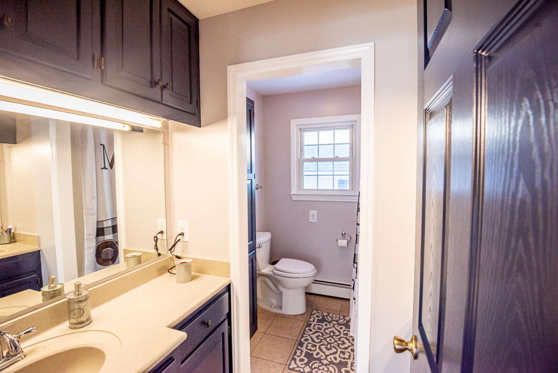 "His" bathroom offers a double vanities and tile flooring.