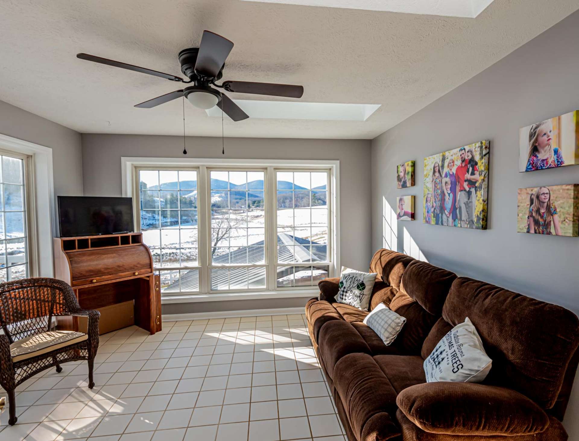 You can enjoy the beauty of the outdoors all year long in this light filled sun room  with floor to ceiling windows and skylights.