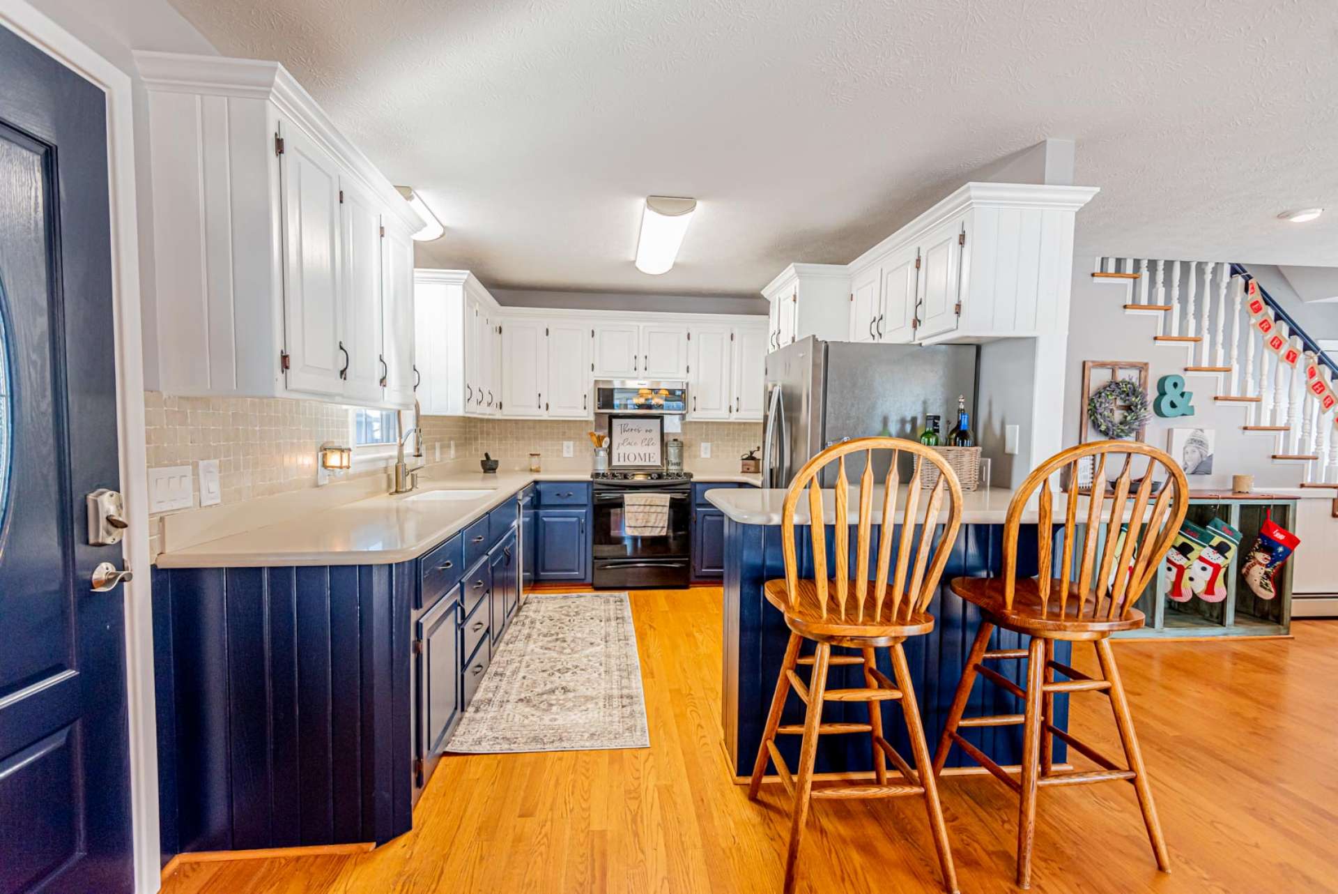 The spacious kitchen area features stainless appliances and plenty of work and storage space that includes a bar with seating.