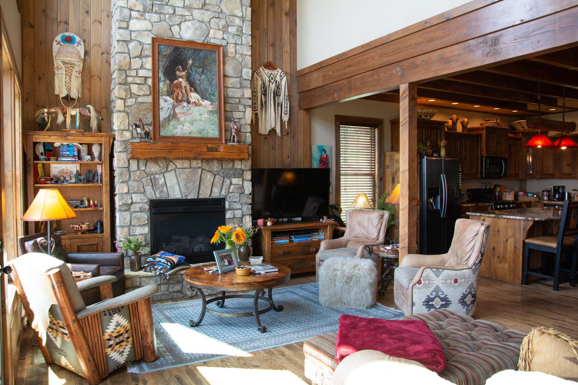 The main level offers a spacious vaulted great room featuring exposed beams, a 2-story stone fireplace and a wall of windows filling the area with natural light and the incredible views.