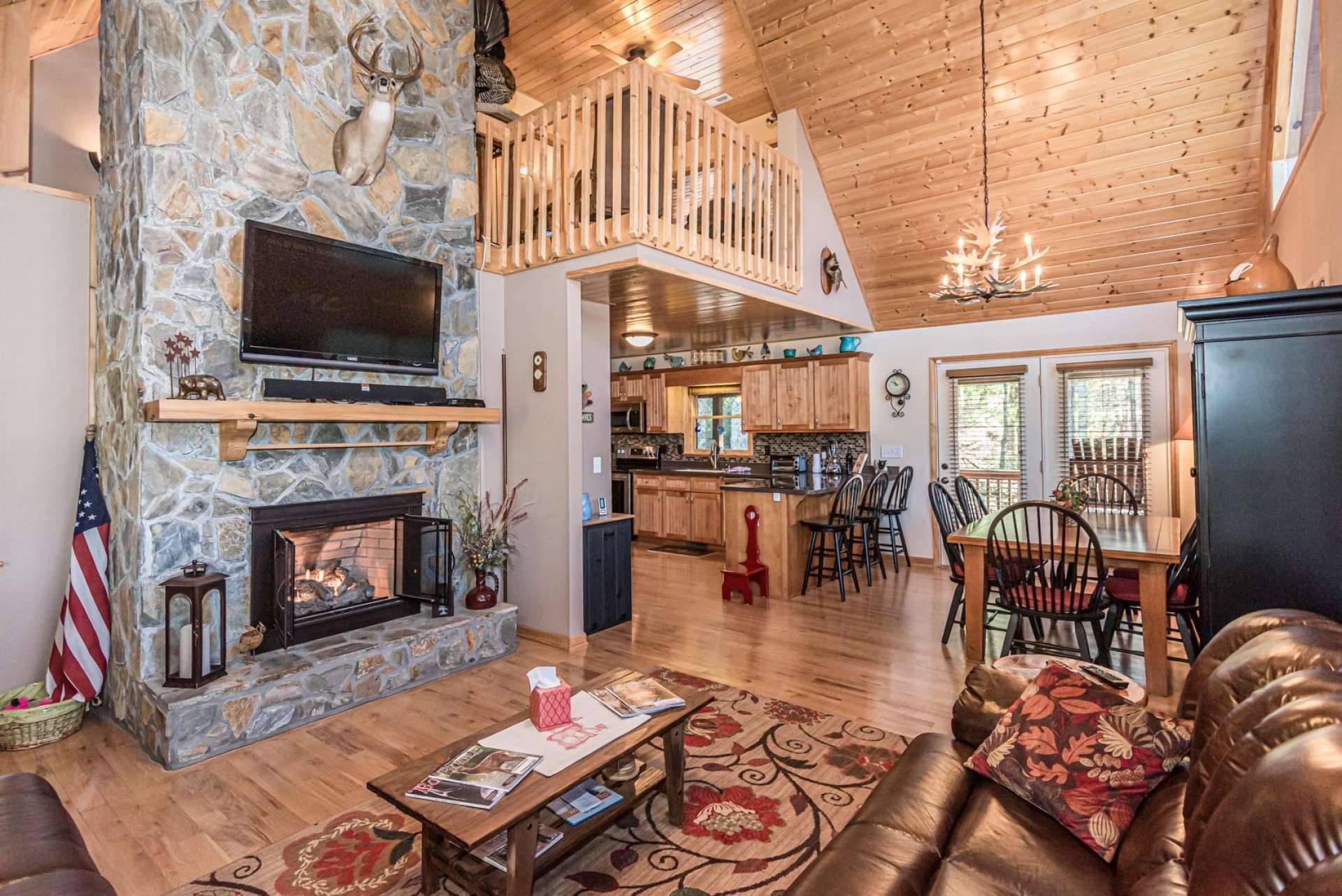 Upon entering the cabin, you immediately get that "I'm home" feeling. The great room welcomes you with a vaulted wood ceiling, a soaring stone fireplace, wood floors, and a wall of windows filling the cabin with natural light.