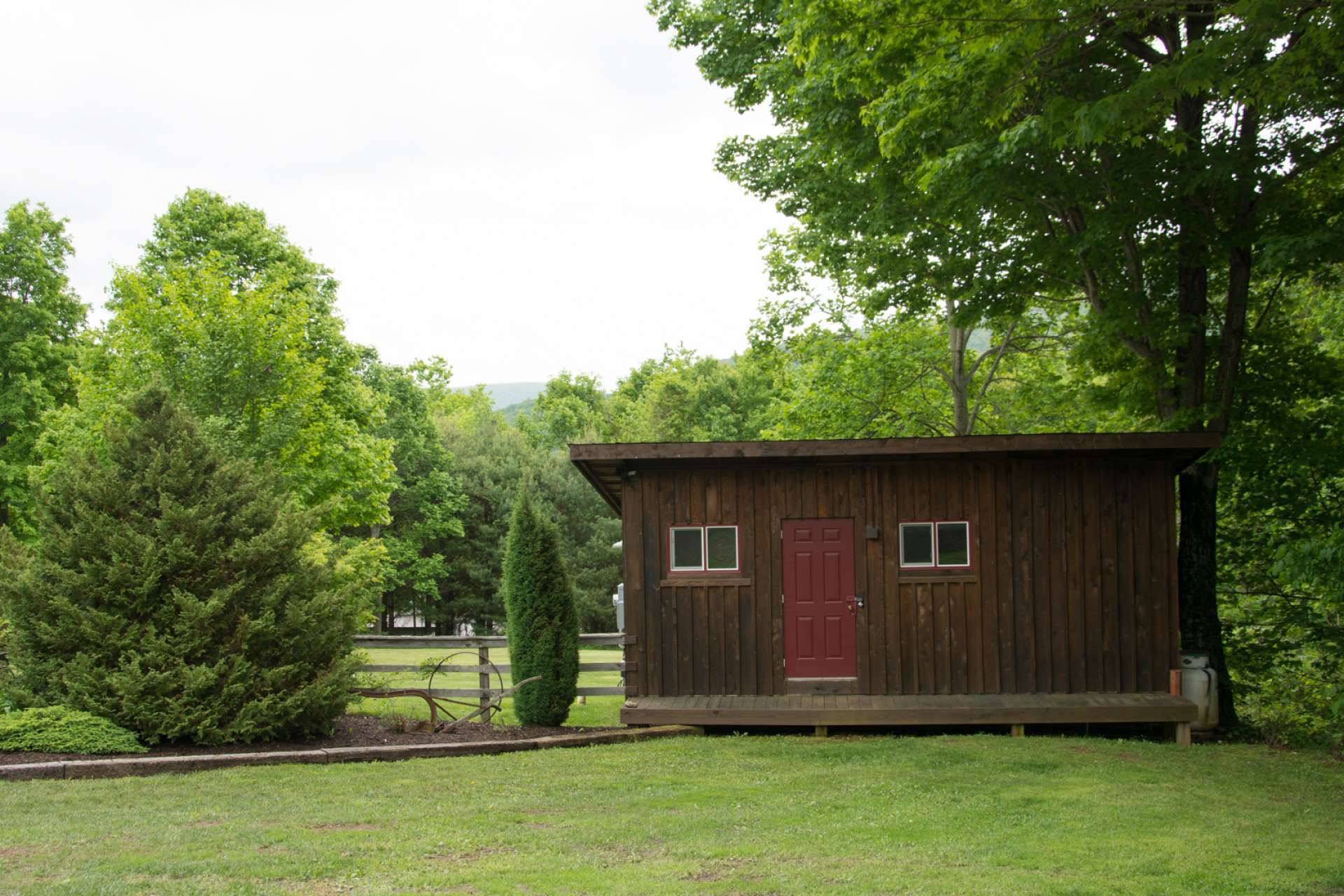 Includes a bunkhouse with a full bath and storage space for outdoor equipment/toys, a second shed which contains the hot water wood stove and also an equipment garage attached to the 2-car garage.