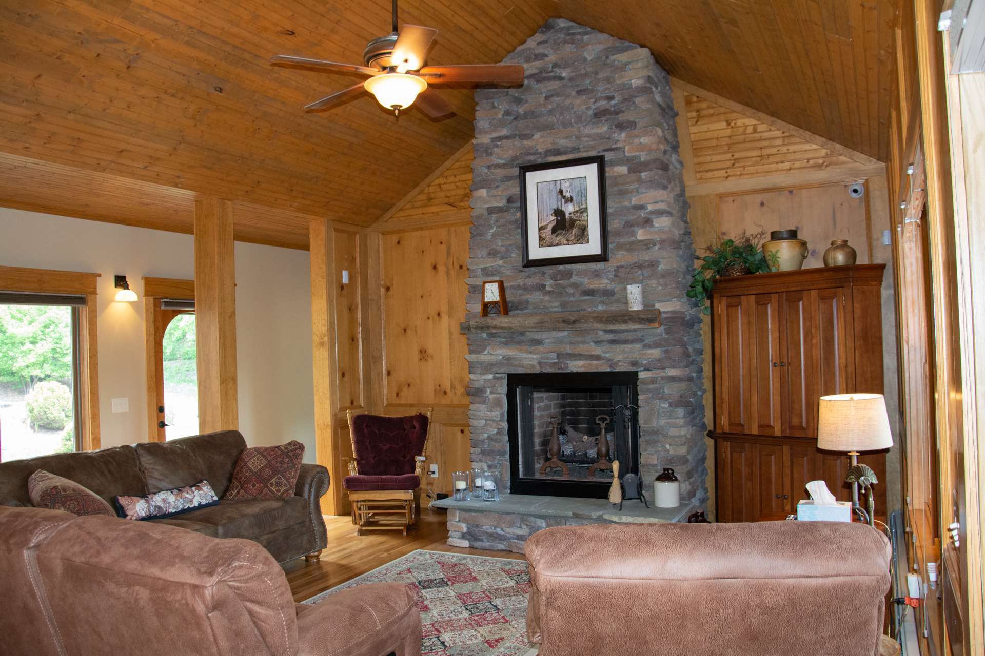 Entertain in grand style in the oversized living room graced by soaring vaulted wood ceiling and cozy floor to ceiling stone fireplace, currently with gas logs.