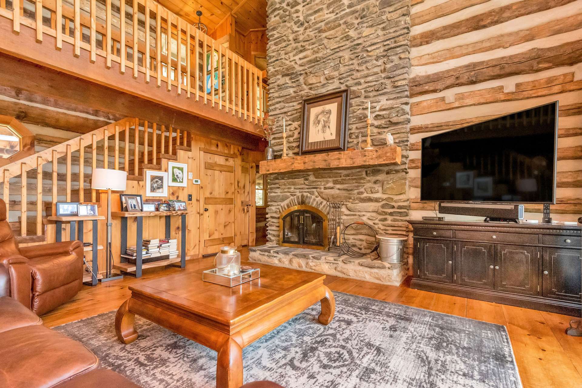 The wood-burning fireplace is a grand focal point with a peek of the second-floor living area.