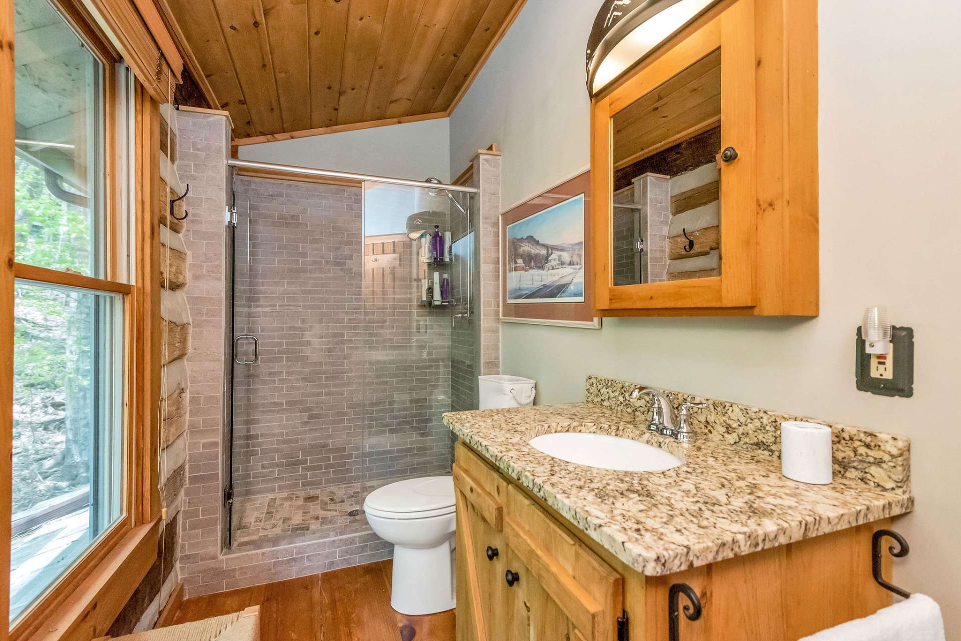 Upper level bath also features granite counter tops and a walk-in shower with glass door.